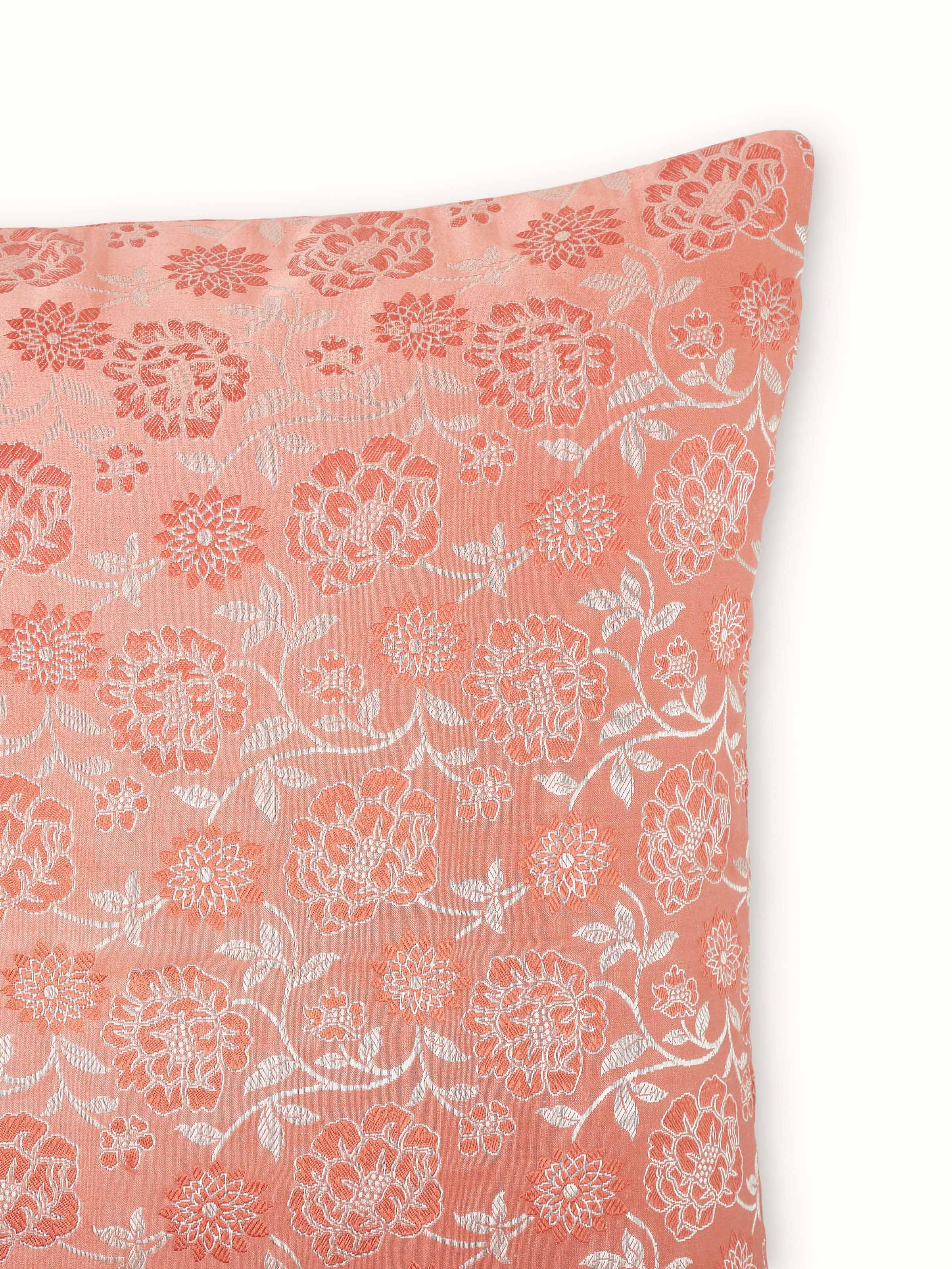 Angled view of Jangala peach jaal silk brocade Banarasi handloom cushion cover displaying the rich texture and colors.
