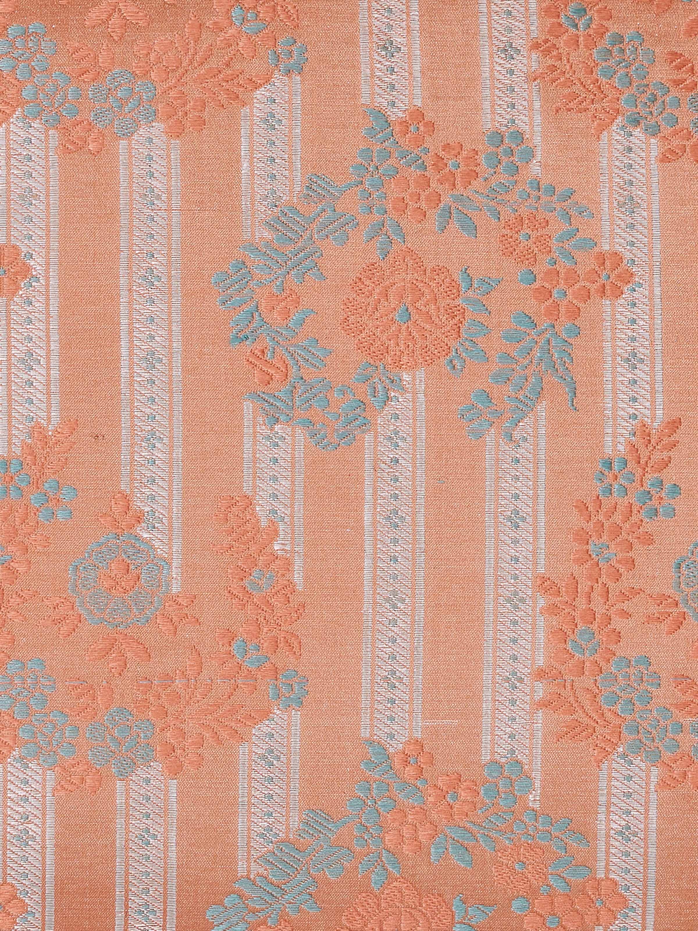 Angled detail shot capturing the rich Banarasi weave and peach silk texture