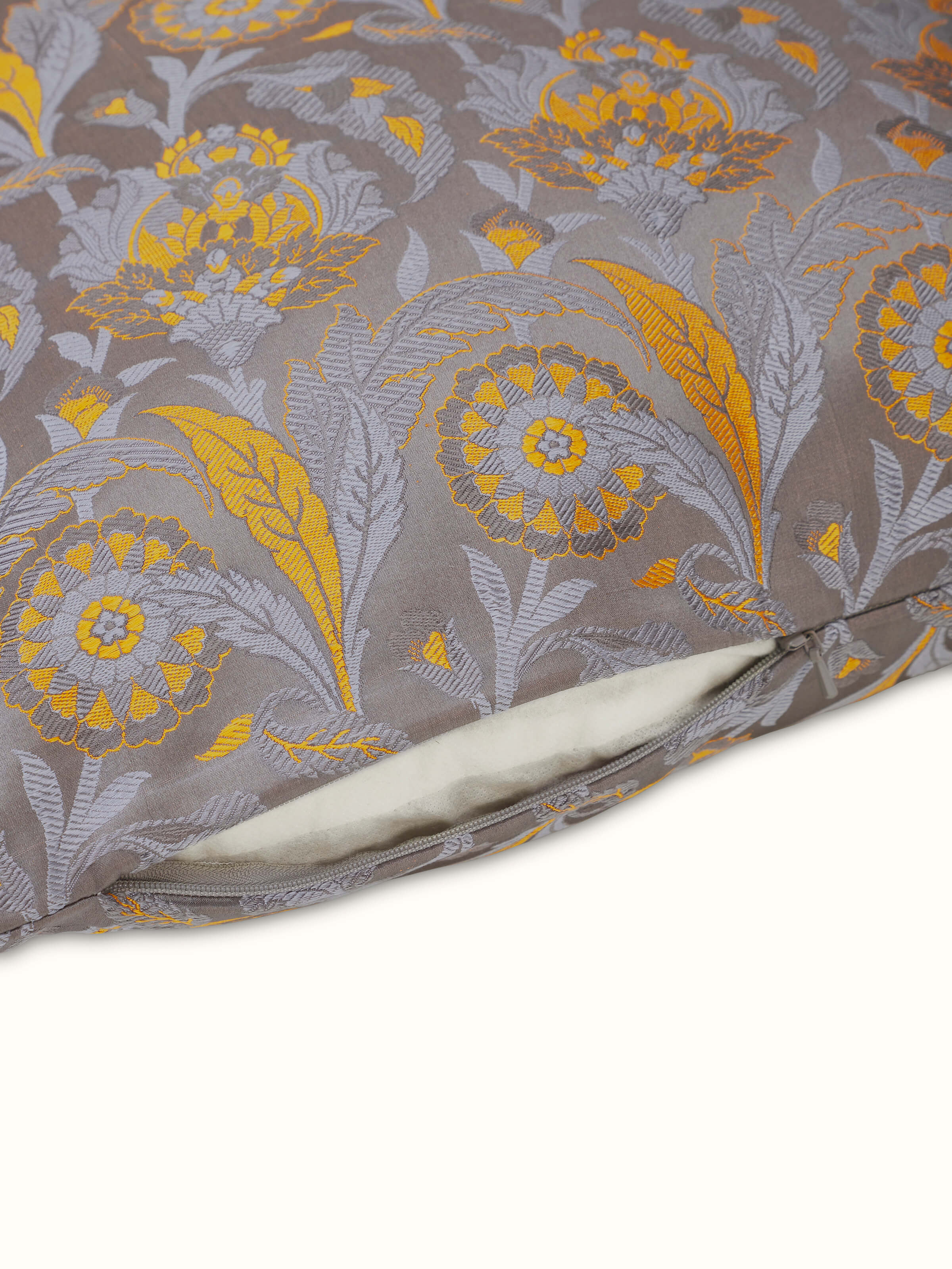 Angled view of grey floral handloom silk cushion cover with Banarasi weaving