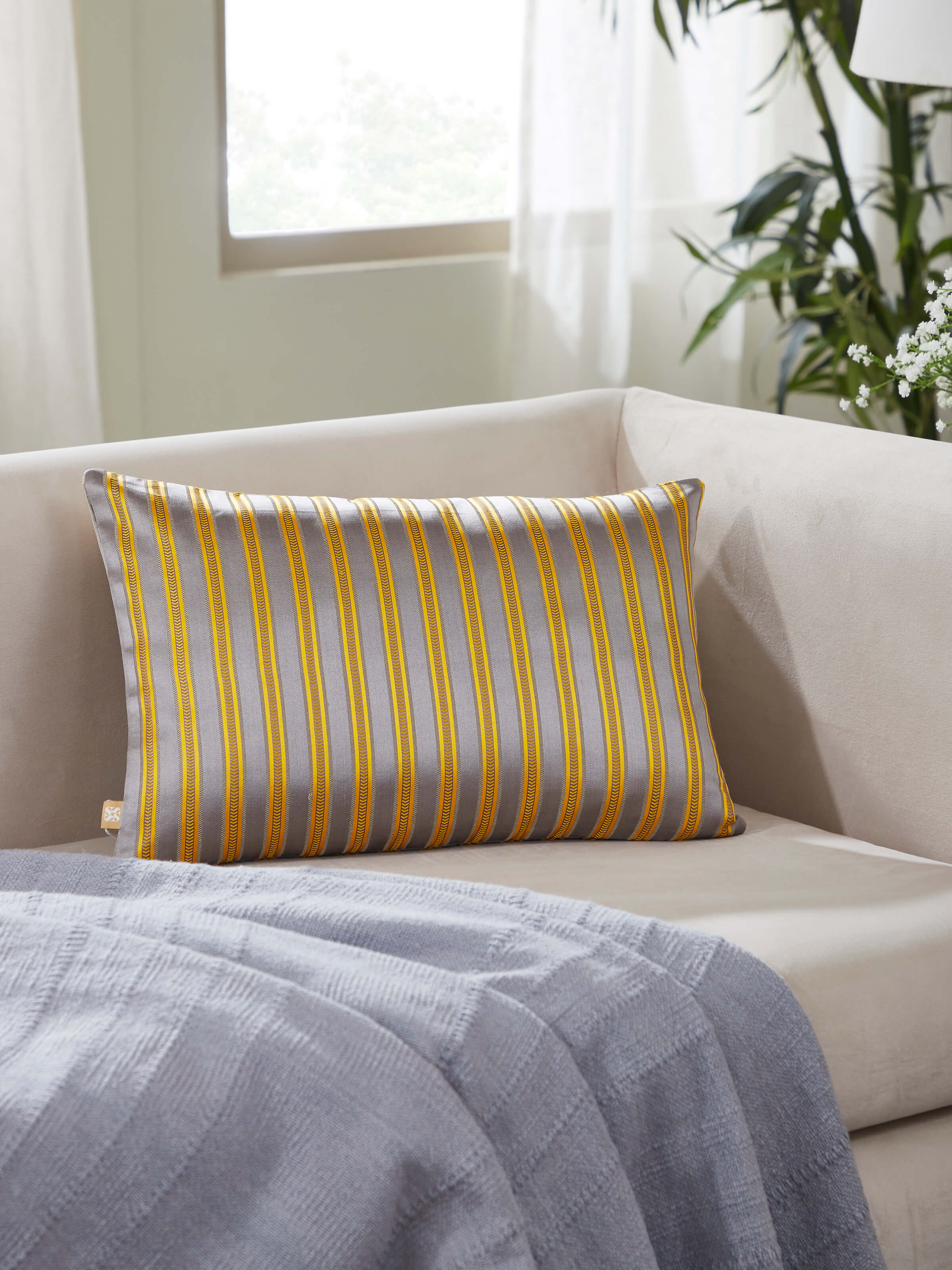 Side view of Aruni grey stripe silk mashru Banarasi handloom cushion cover, showcasing the texture and stripe details.