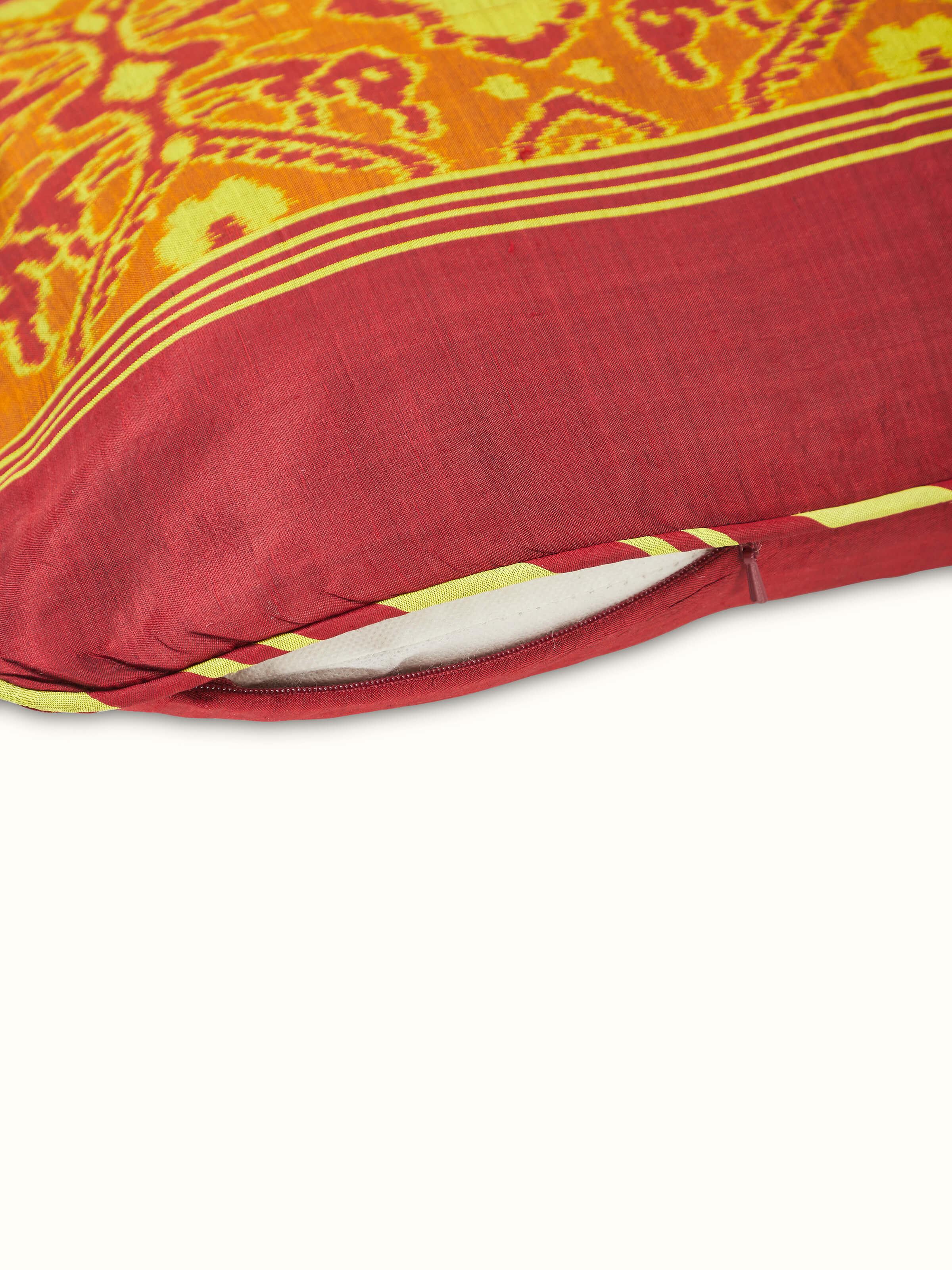 Angled view of the Bhoomi Red Stripe Silk Odisha Handloom Ikat Cushion Cover, capturing the cushion's design and color details