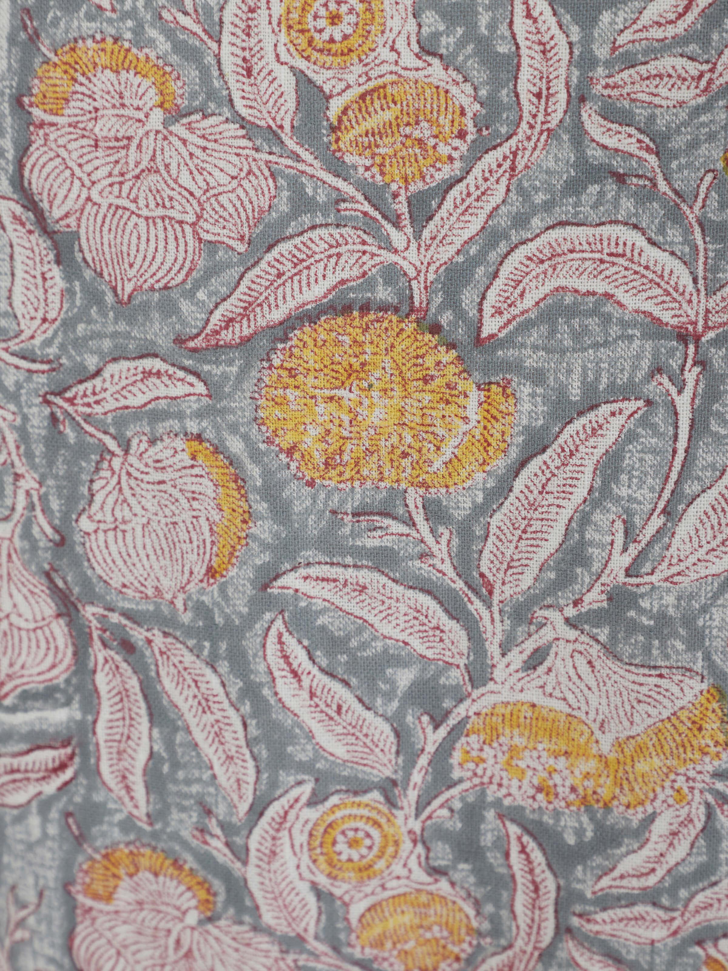 Folded view of grey floral cotton Sanganeri block printed apron showing the overall floral print and cotton material.