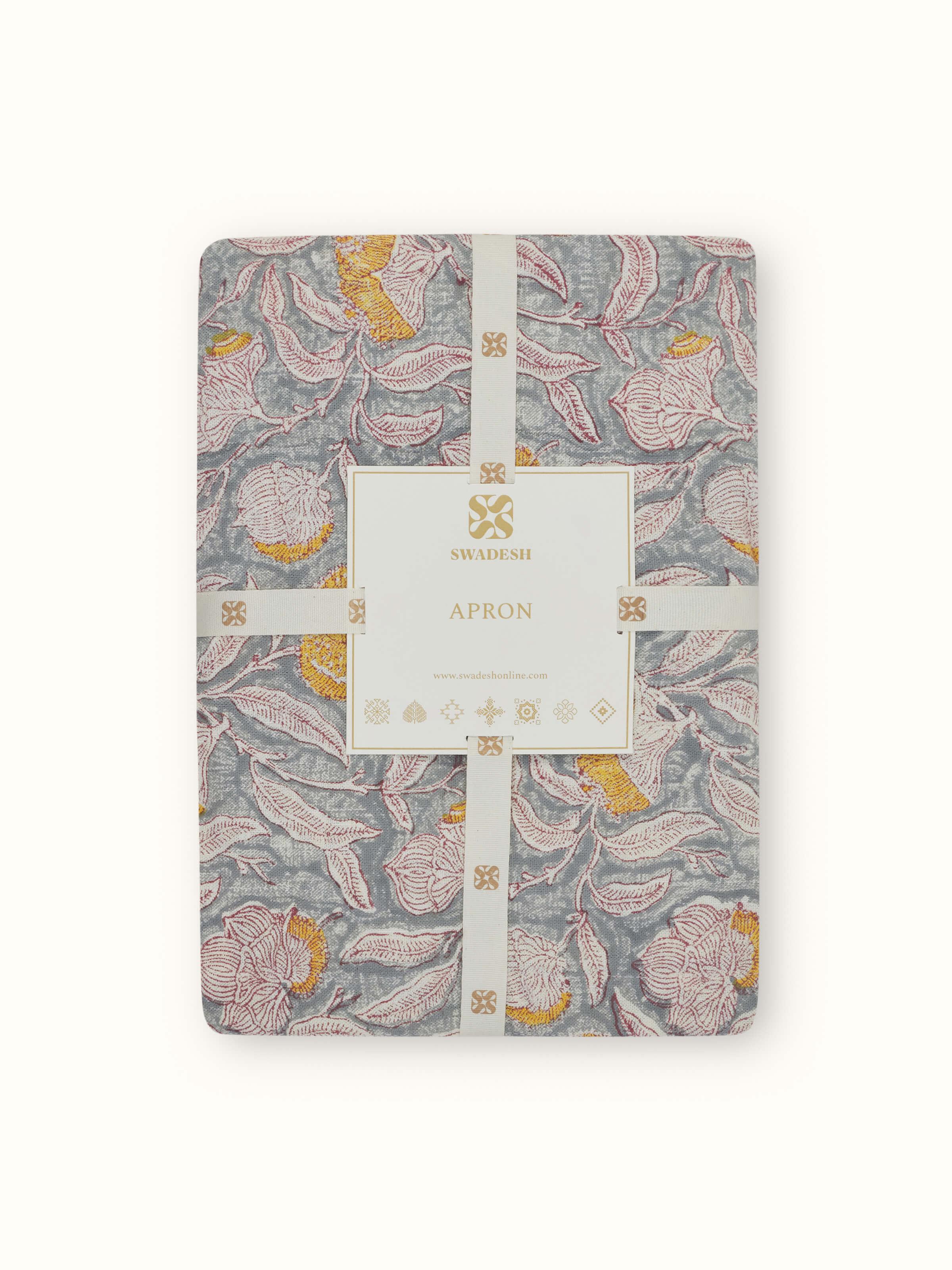 Full view of grey floral cotton Sanganeri block printed apron showing the design and adjustable straps.