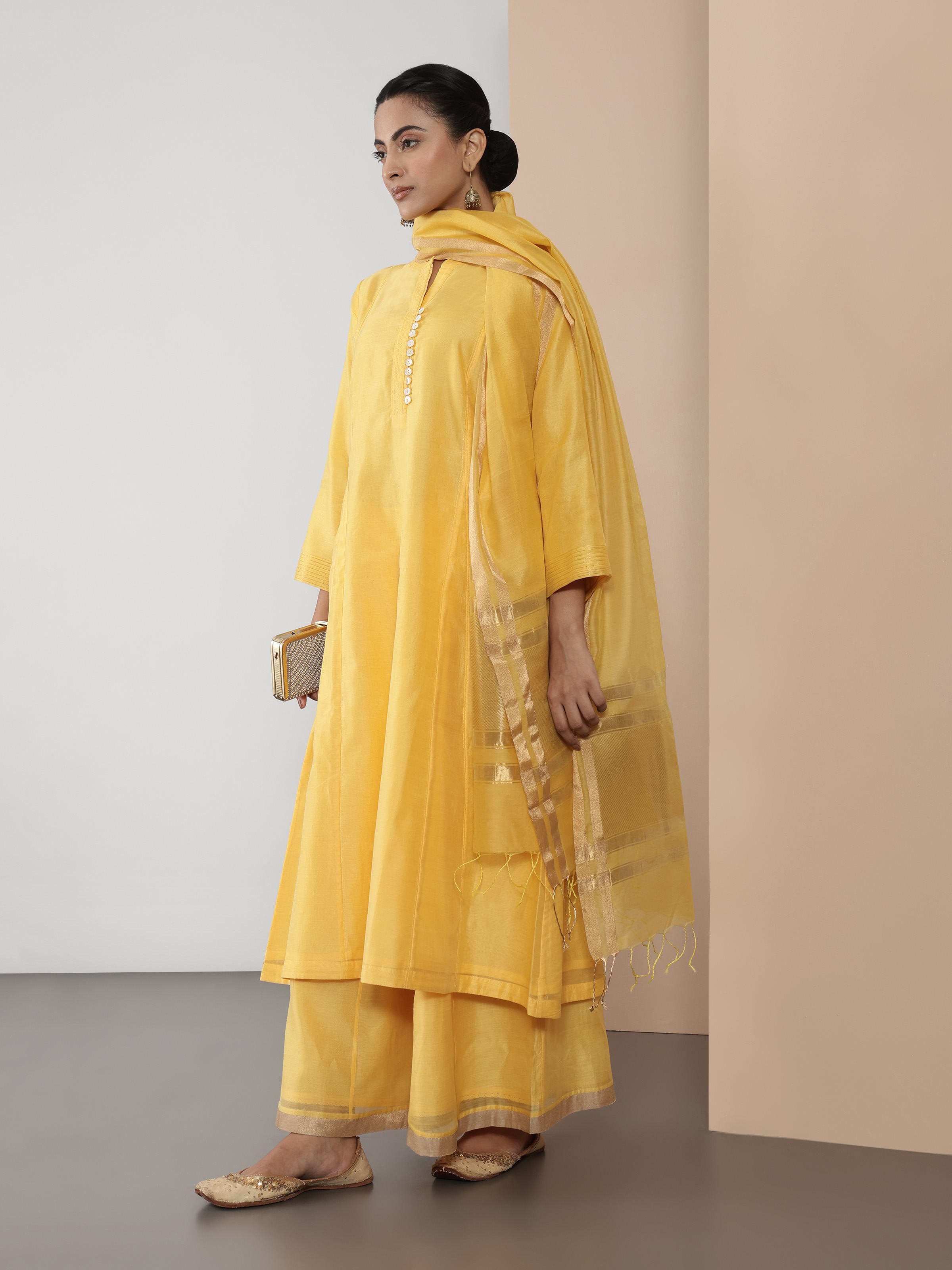 Lifestyle view of yellow Chanderi kurta styled with ethnic trousers and accessories