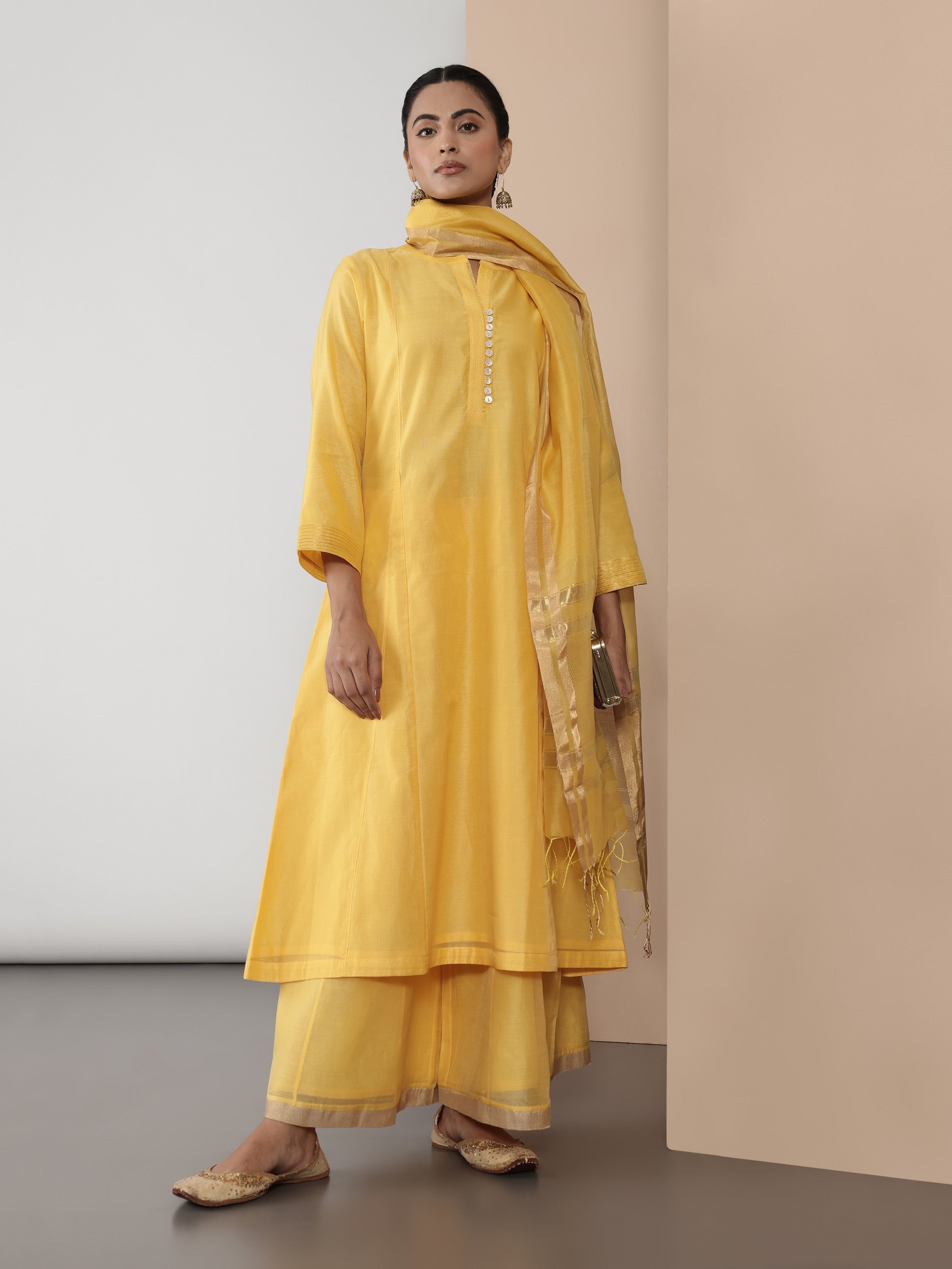 Angled lifestyle view of yellow cotton silk kurta showcasing elegant texture and side slit