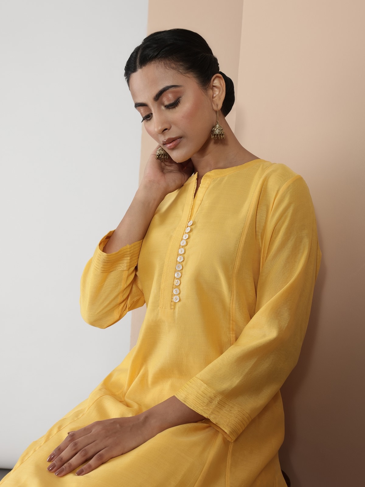Side lifestyle view of yellow Chanderi kurta highlighting drape and sleeve details