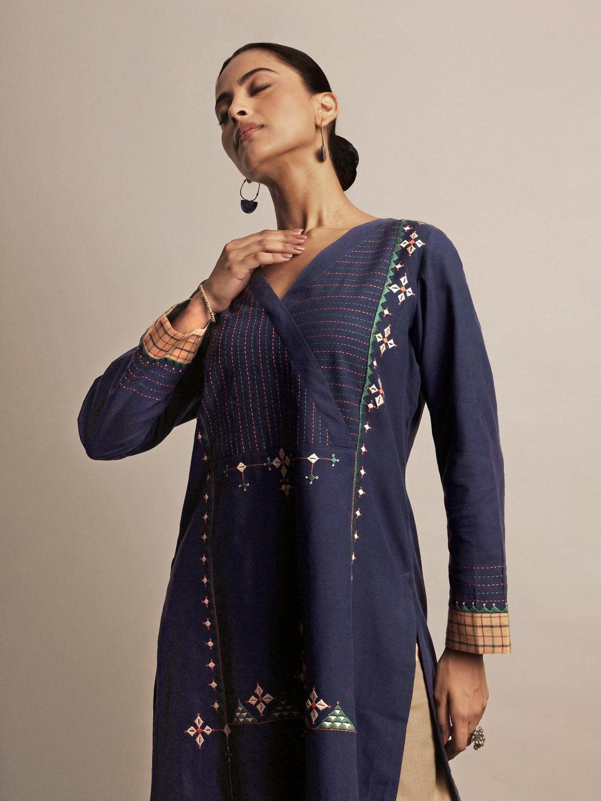 Side pose showing intricate Rajasthani hand embroidery along neckline and sleeves.