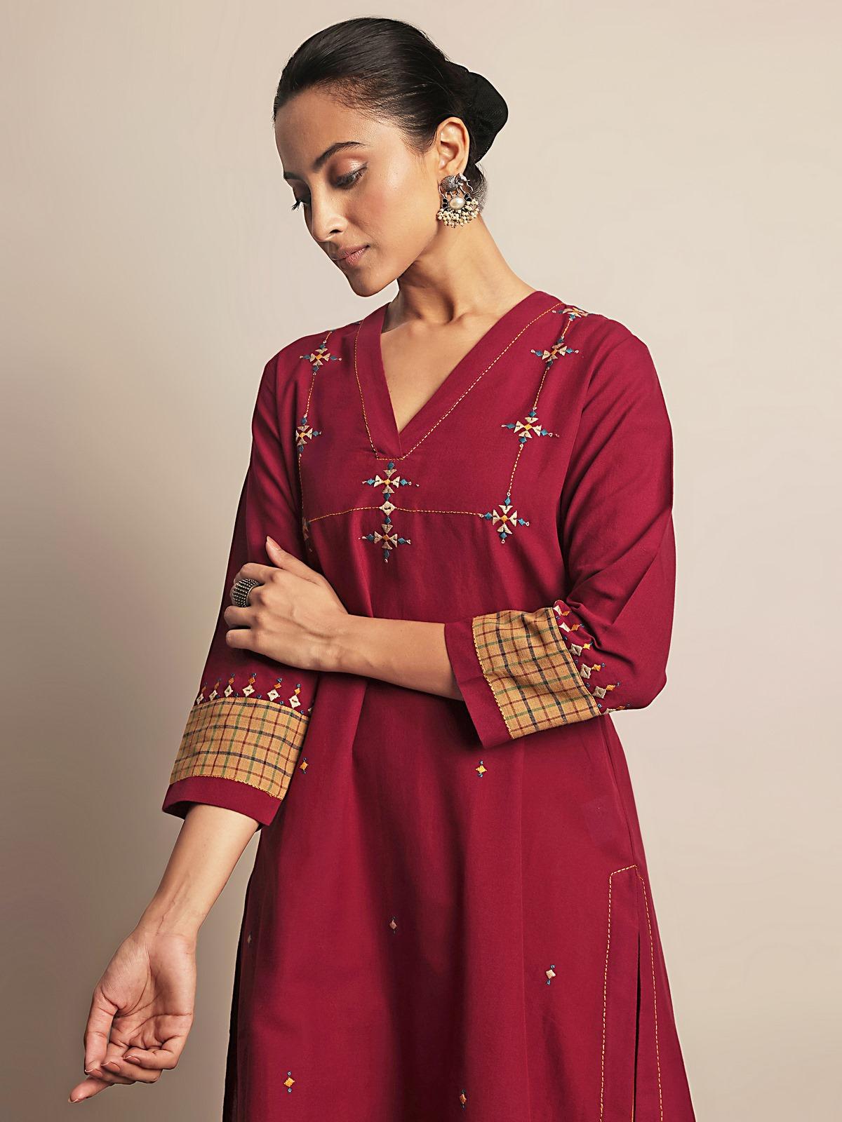 Angled view of maroon cotton Rajasthani embroidered kurta highlighting neckline and sleeves.