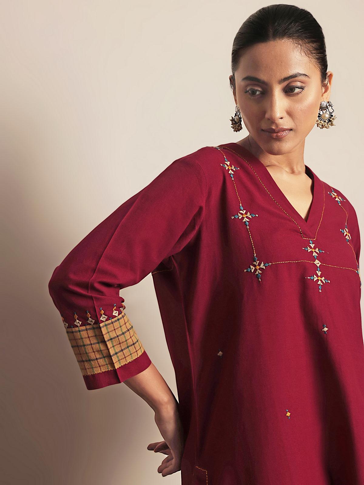 Close-up detail of maroon cotton kurta embroidery and fabric texture.
