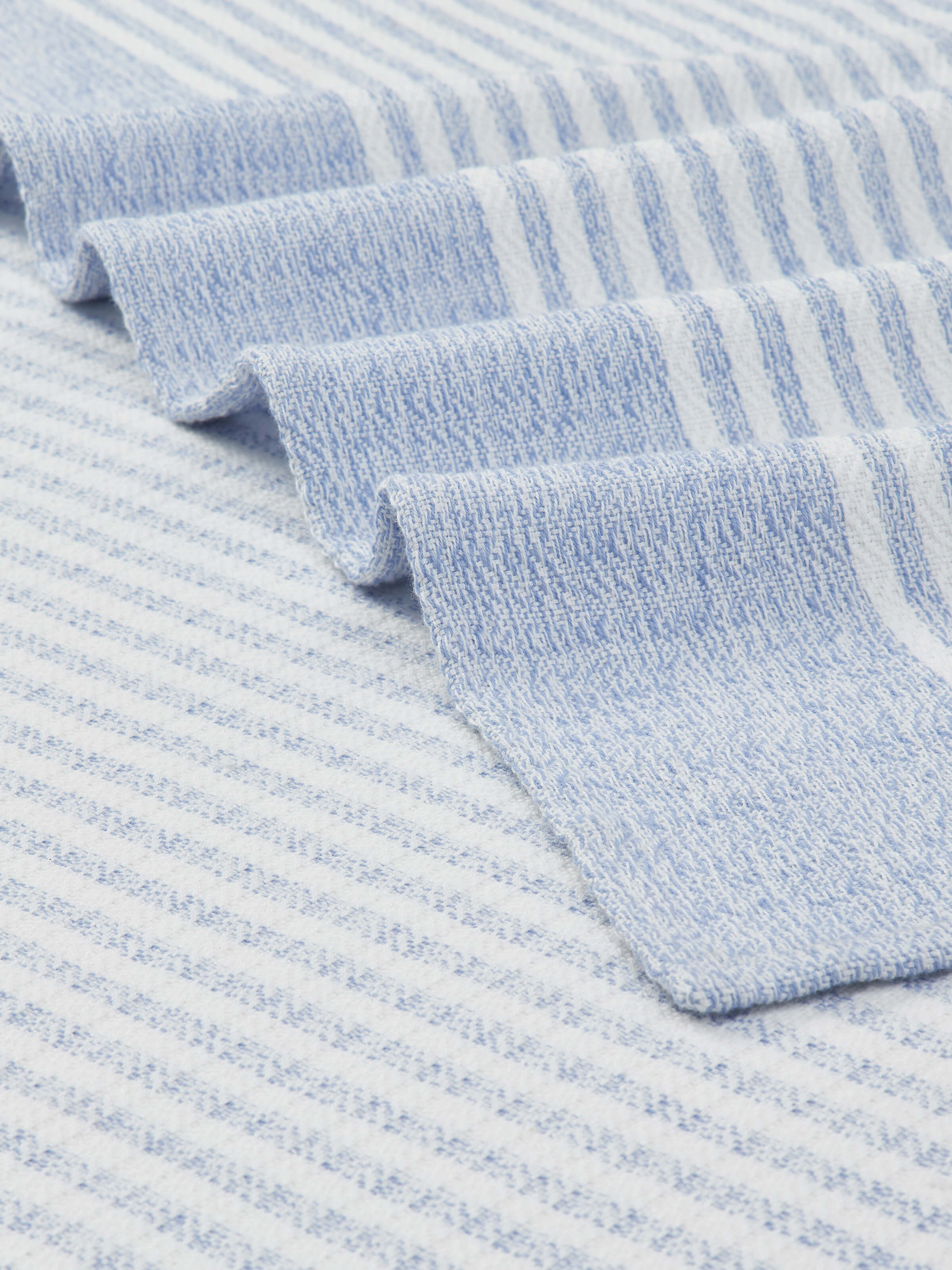 Angled view of Vayana Stripe Blue Stripe Cotton Bath Towel (XL) emphasizing the towel's large size and stripe pattern