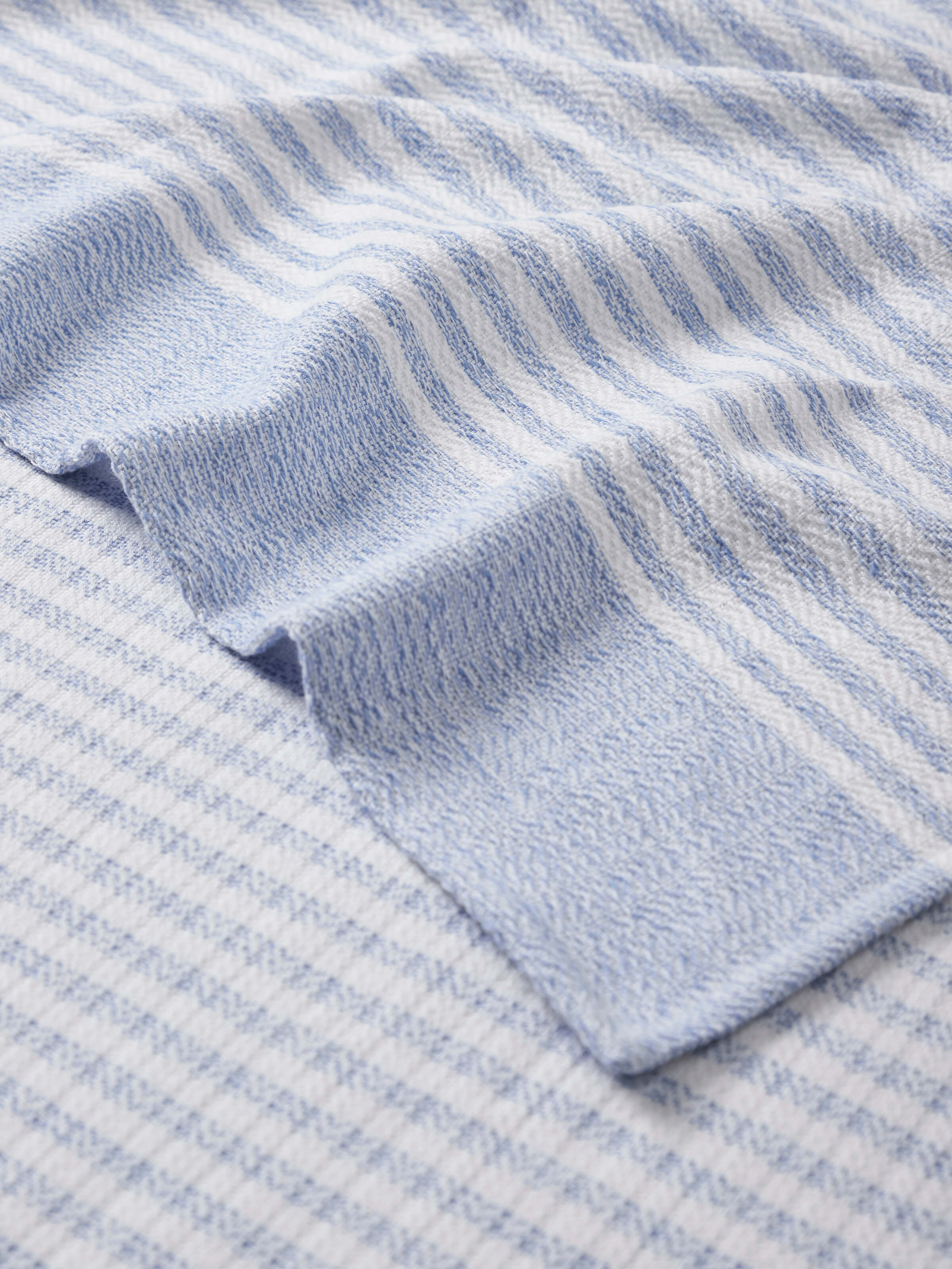 Perspective view of Vayana stripe blue cotton bath towel (L) showcasing the overall design and stripe pattern.