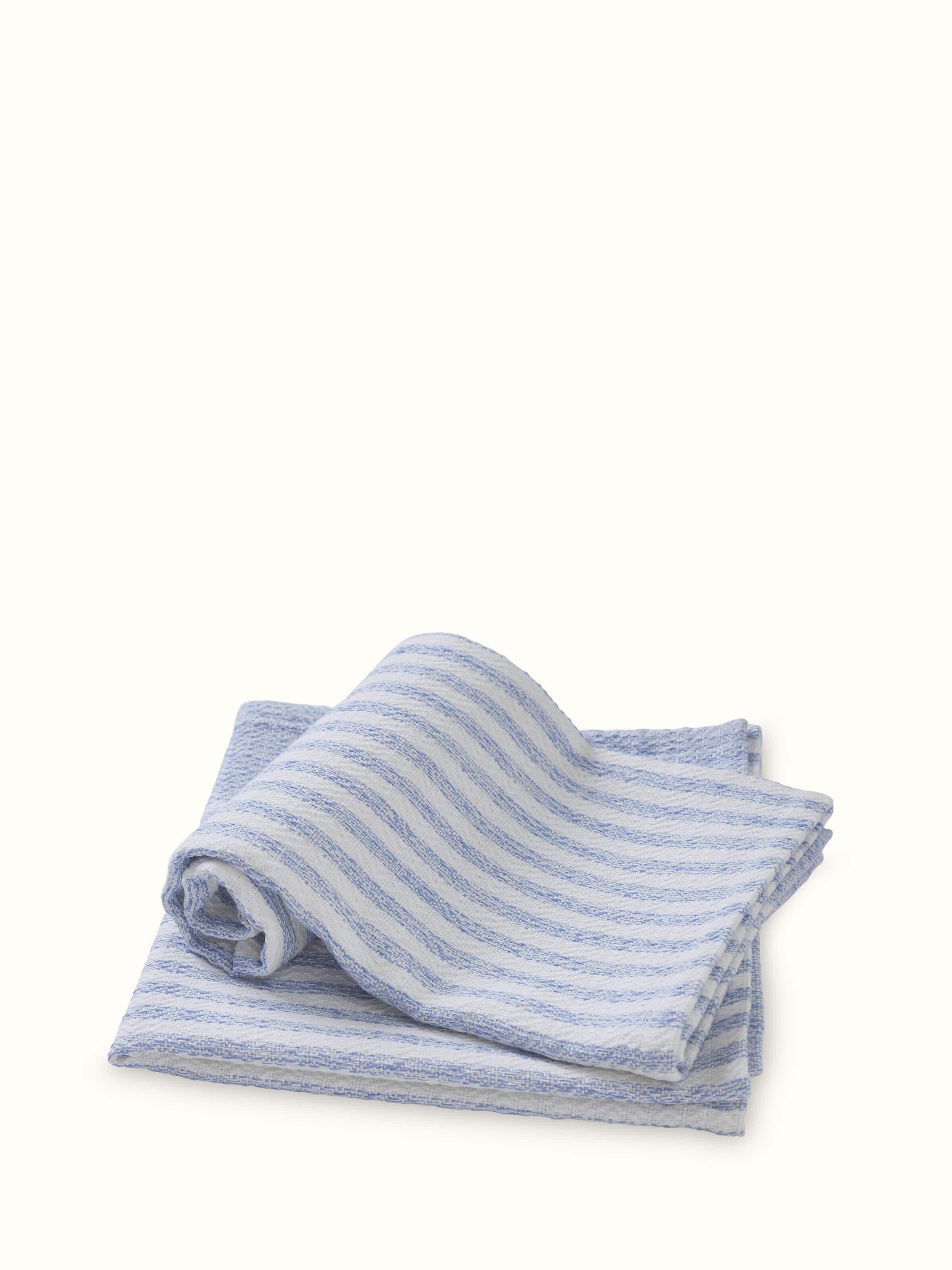 Vayana stripe blue cotton hand towels displayed on a towel rack, showing their design and use in a bathroom setting.