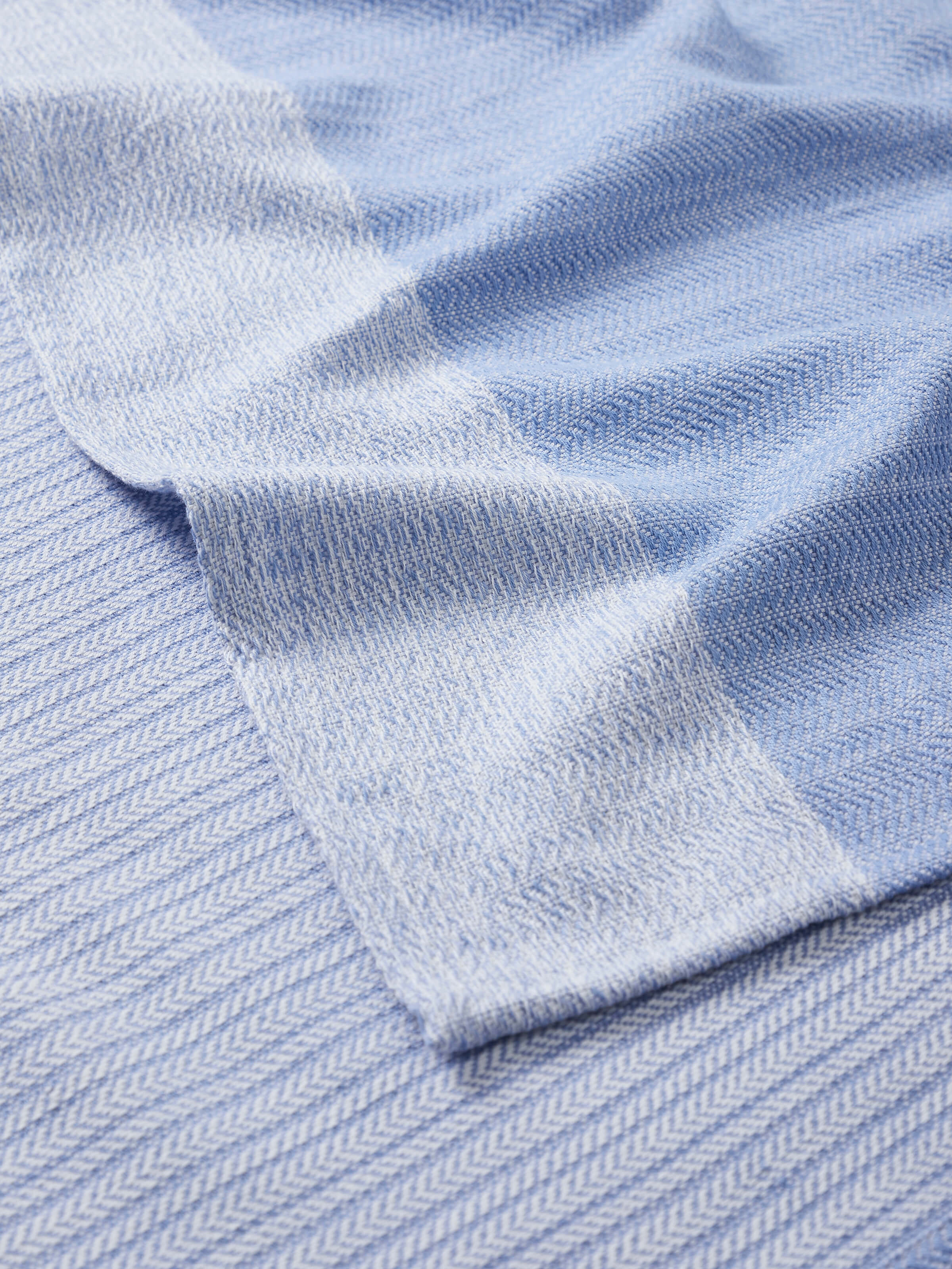 Angled view of Vayana Solid Blue Cotton Striped Bath Towel (L) showing overall design and stripes
