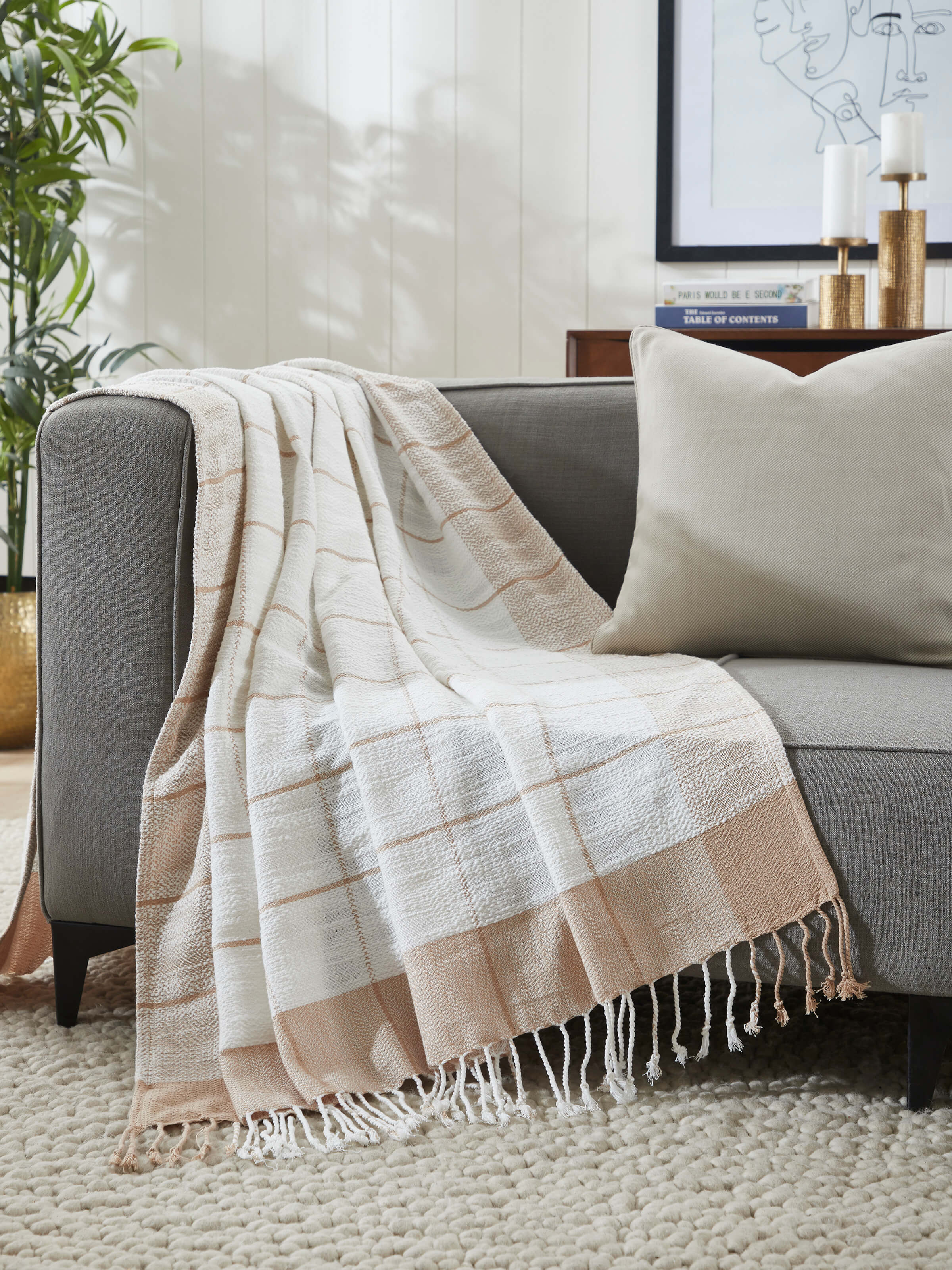 Lifestyle image of cotton throw styled on a sofa, adding warmth and neutral elegance.