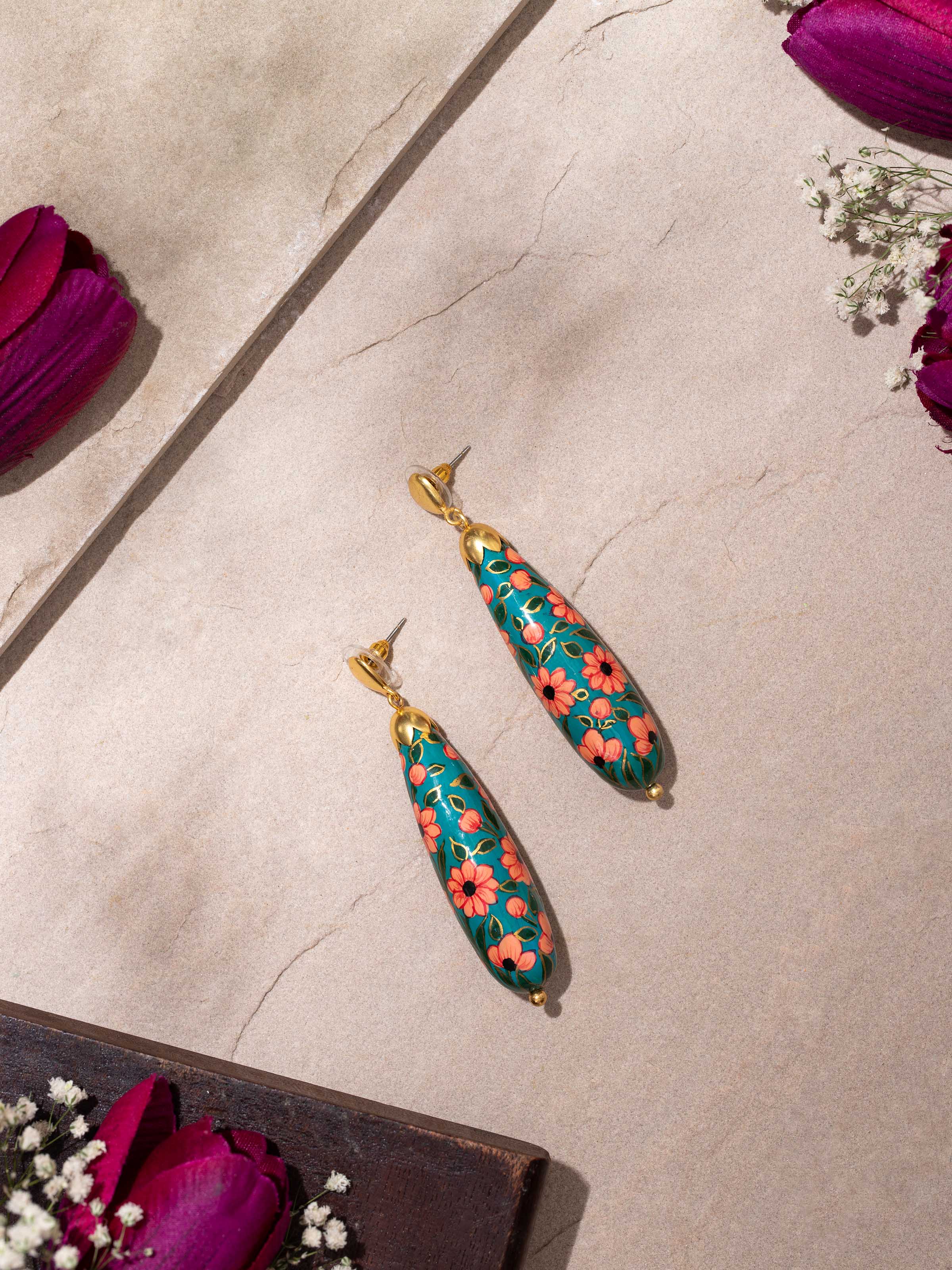 Close-up view of papier-mâché drop earrings highlighting the texture and craftsmanship.