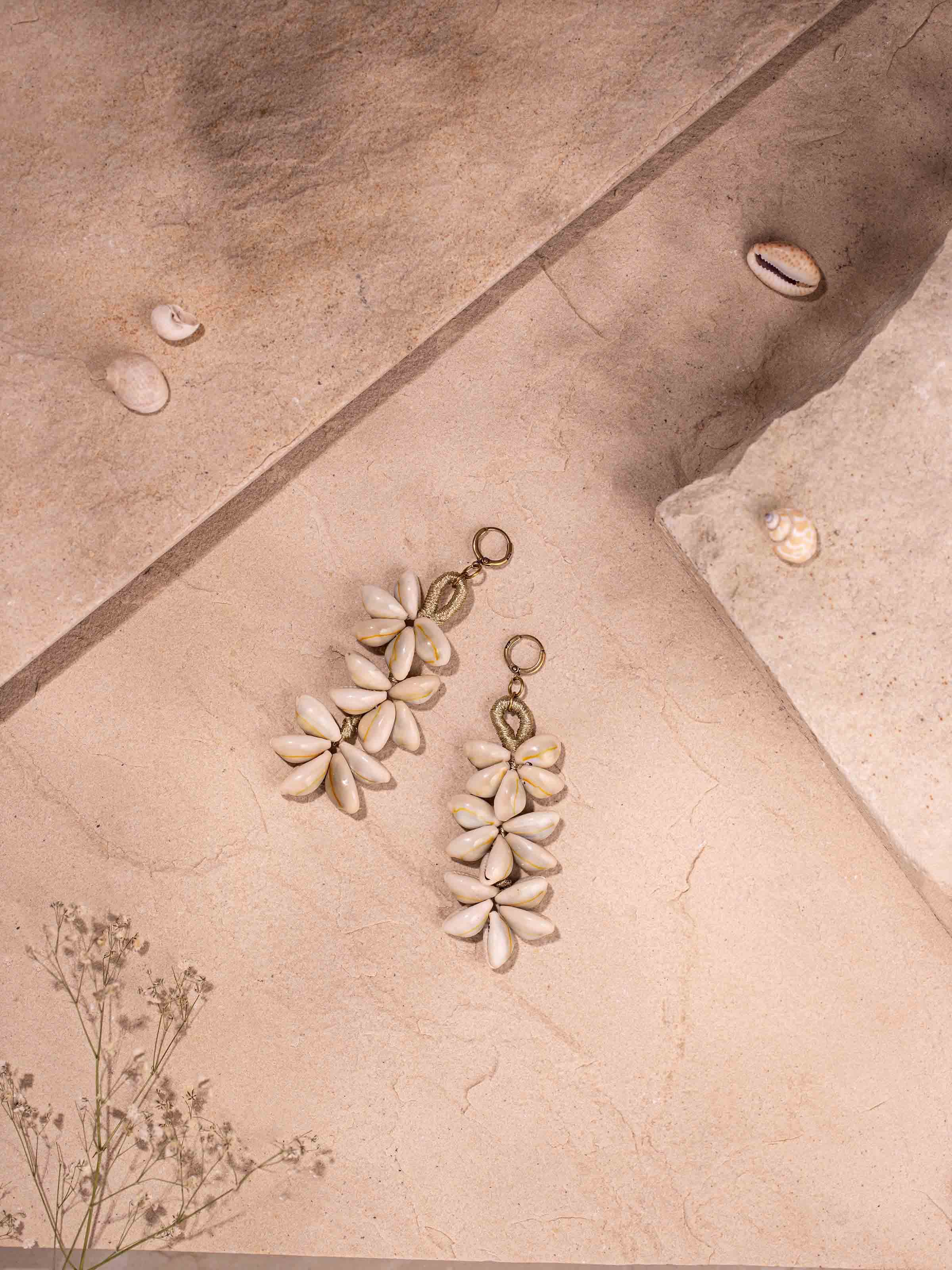 Side view of cowrie shell drop earrings highlighting detailed shellwork and craftsmanship