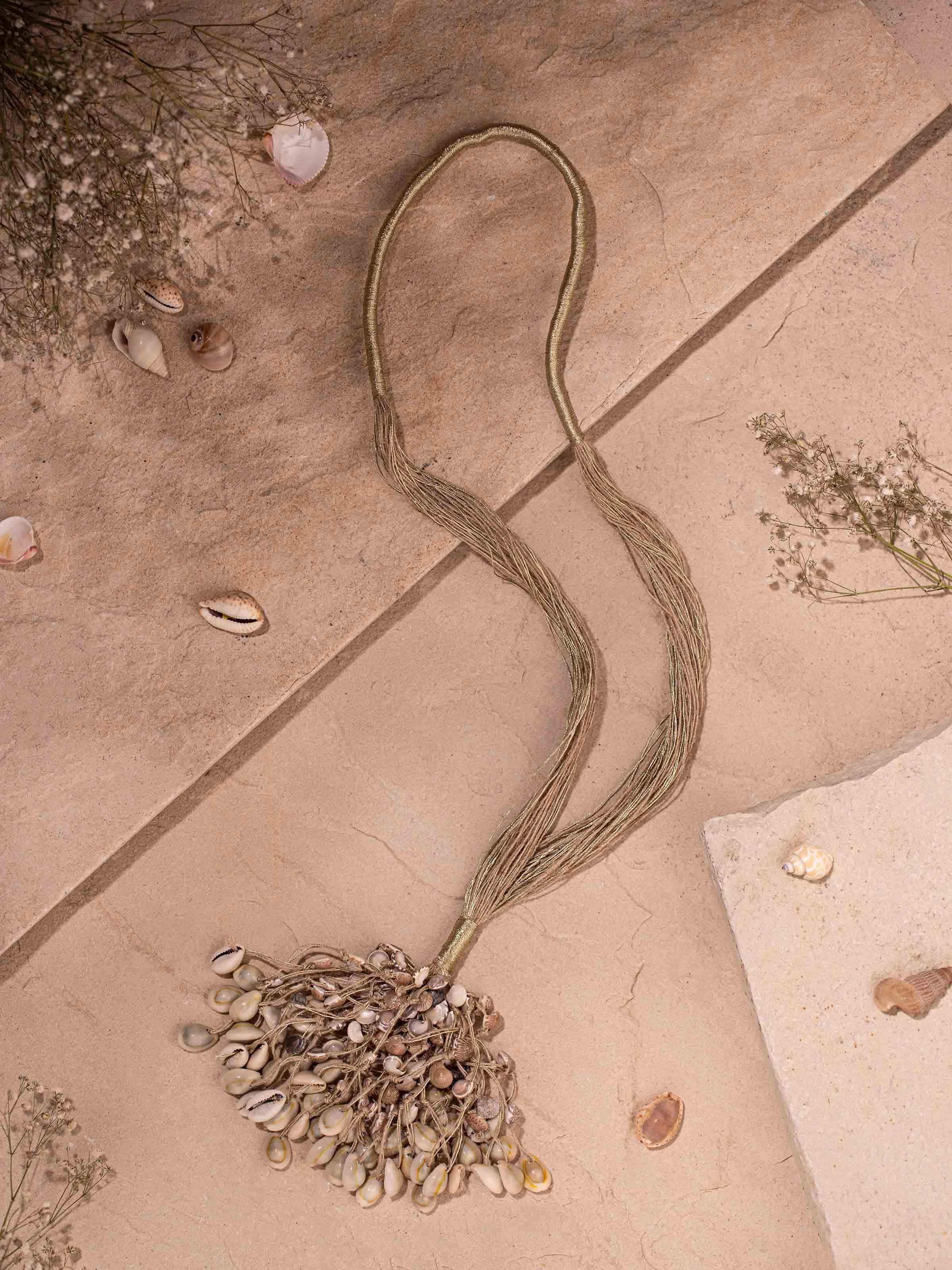 "Close-up of cowrie shell long necklace with focus on shell arrangement"