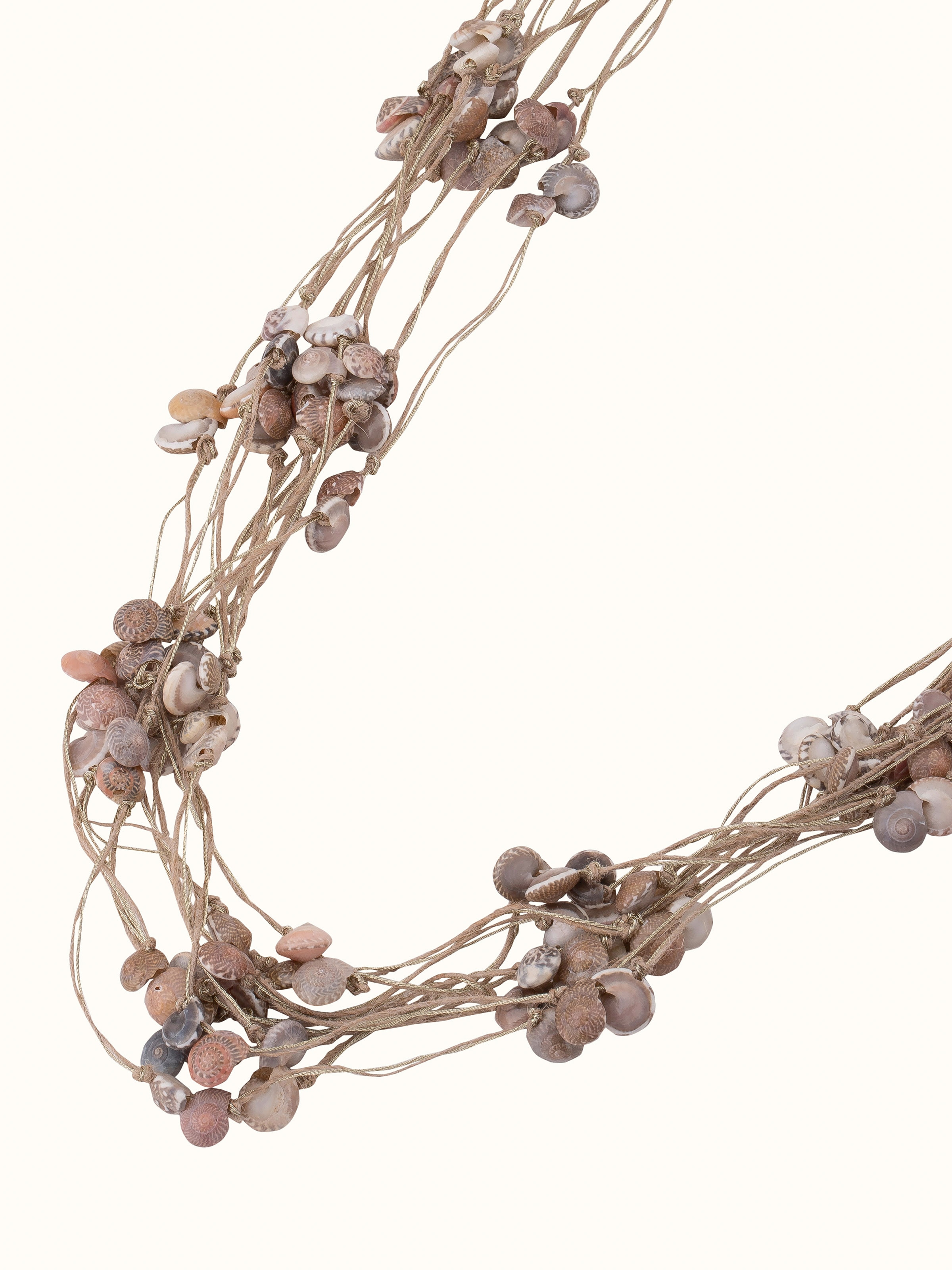 Cowrie shell long necklace displayed on a flat surface highlighting its natural design and elegant craftsmanship.
