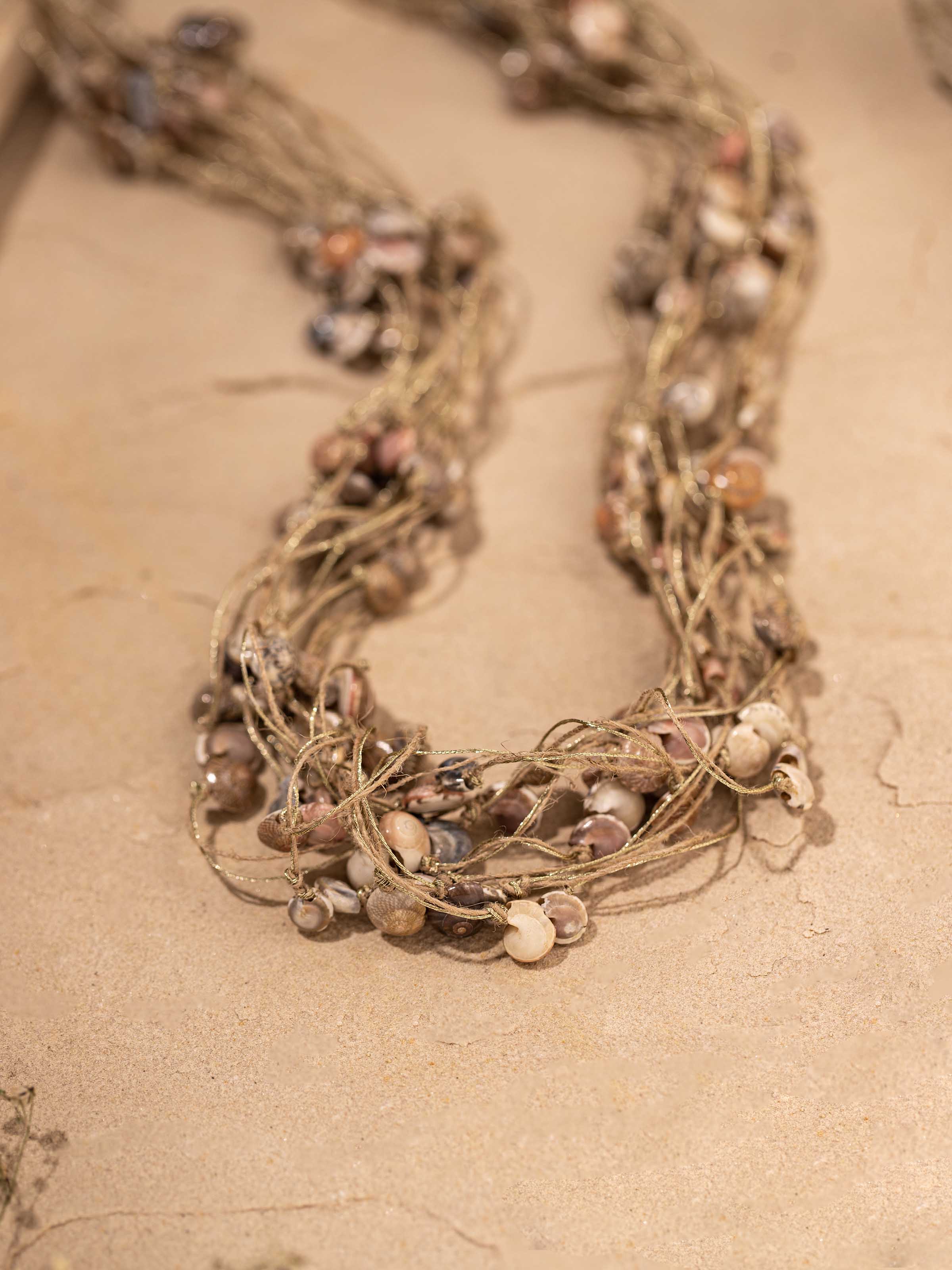 Detailed view of cowrie shell long necklace showcasing its natural shell elements and stylish design.