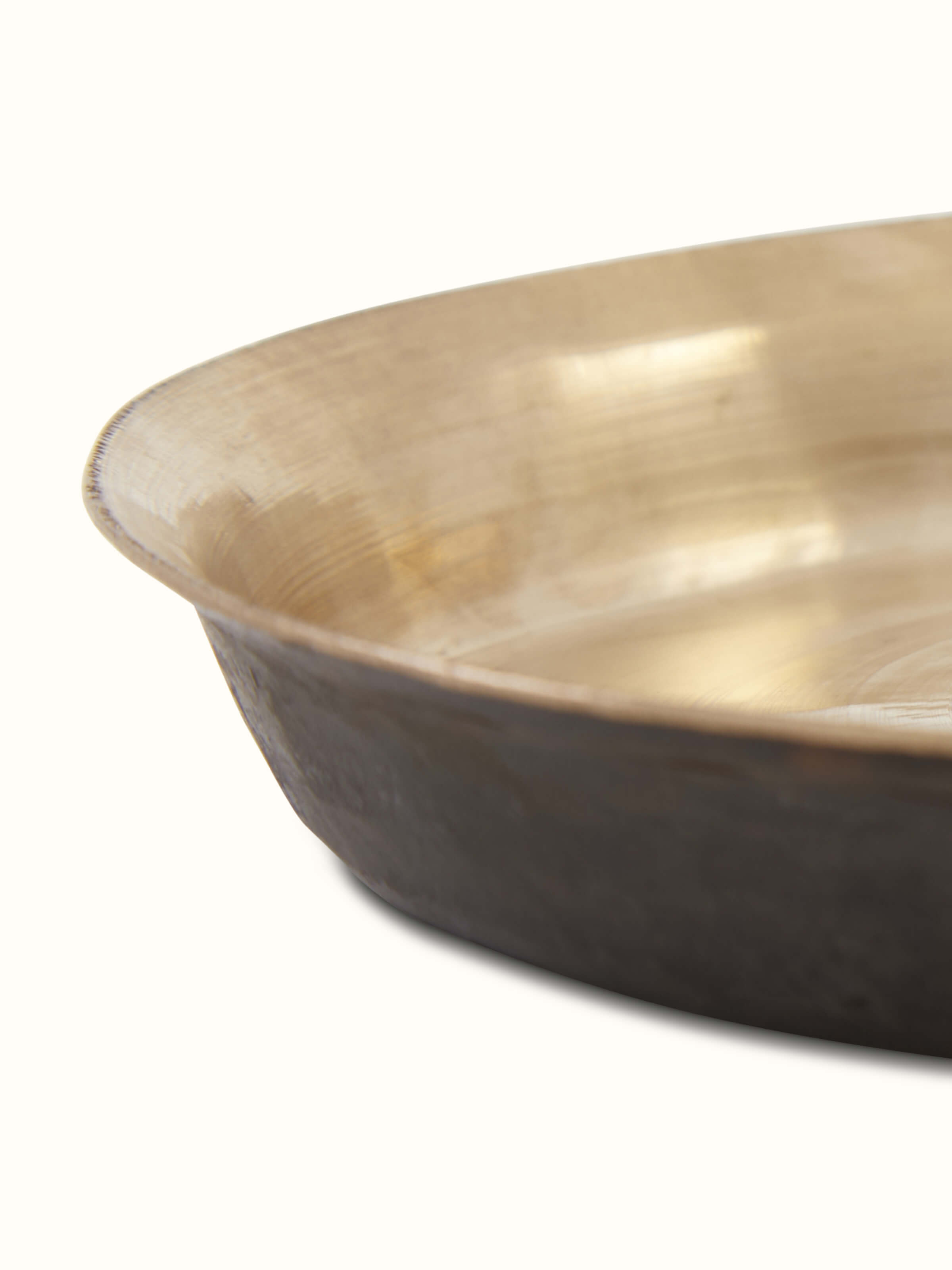 Angled view of bell metal Balisiri side plate, emphasizing the traditional design and reflective surface