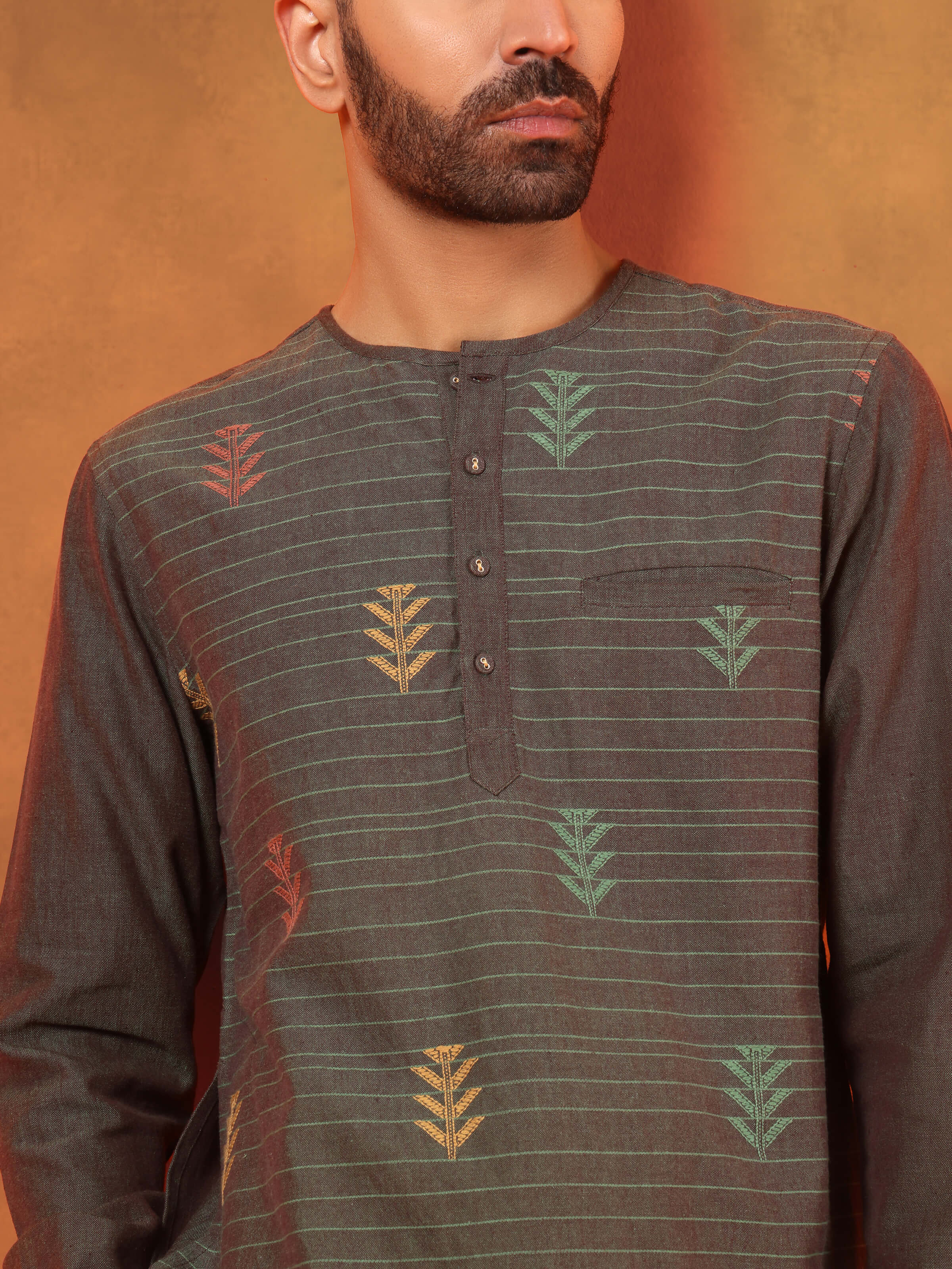 Angled view of extra-weft weave short kurta in brown, highlighting textured detail.