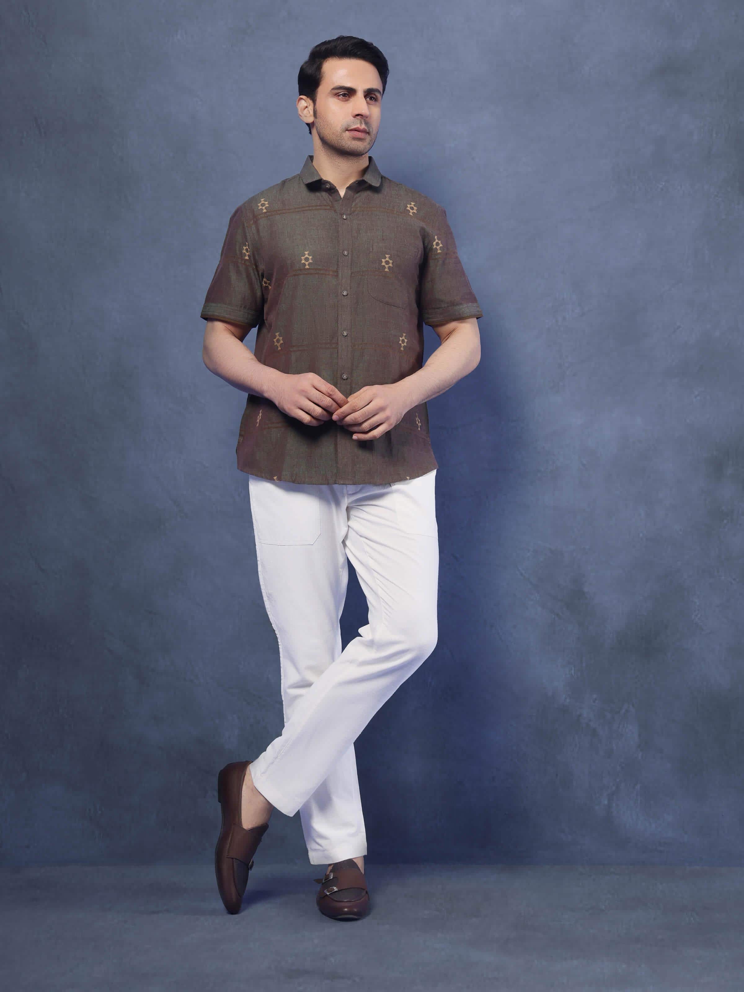 Lifestyle view of brown cotton extra-weft shirt styled casually with rolled sleeves.