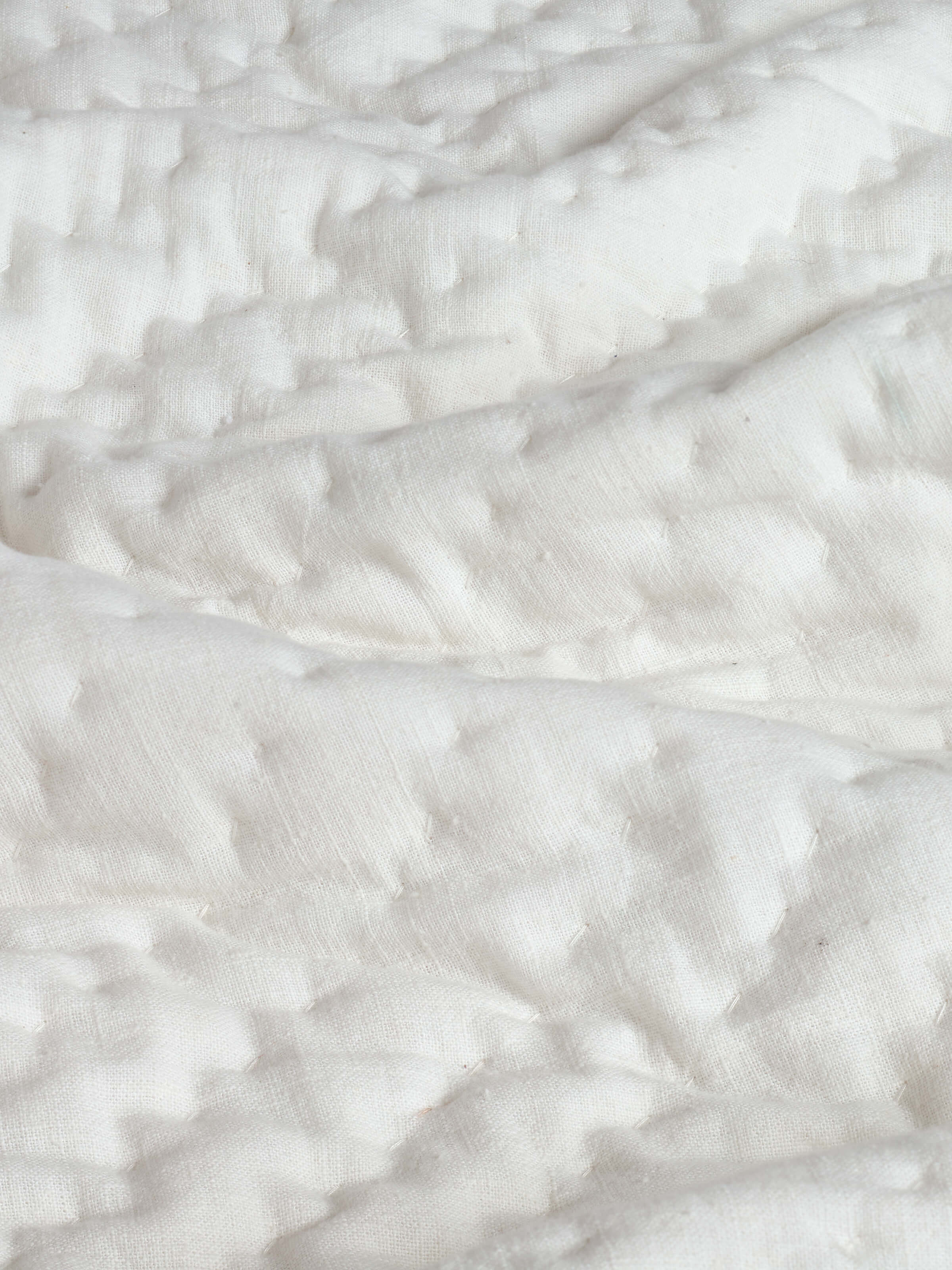 Detailed view of the textured stripe pattern on the Kapasa off-white cotton handloom bedspread