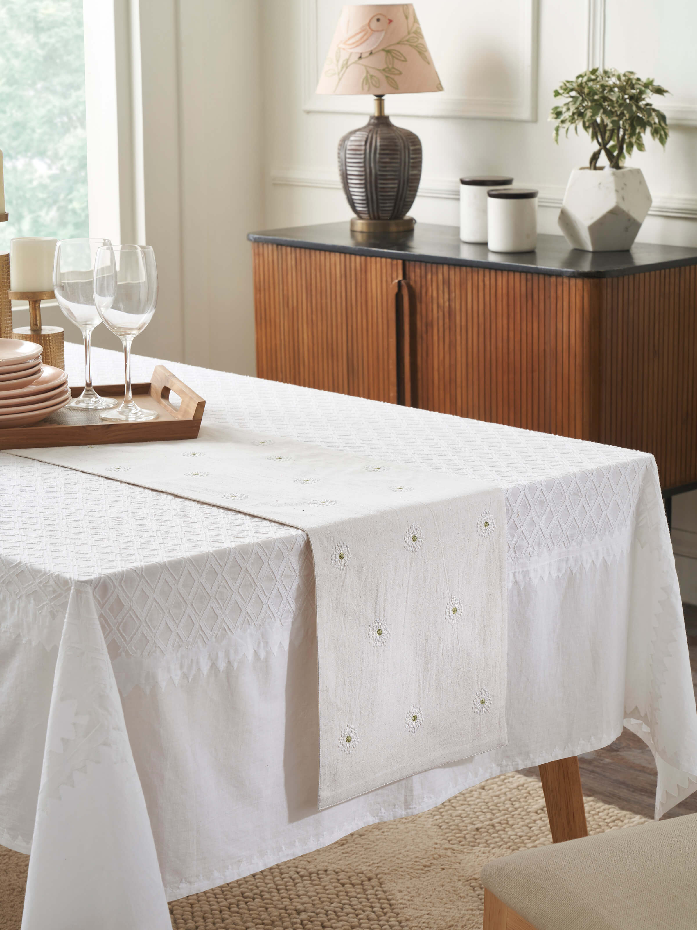 Lifestyle shot of embroidered table runner styled on a dining table, enhancing a serene dining setup.