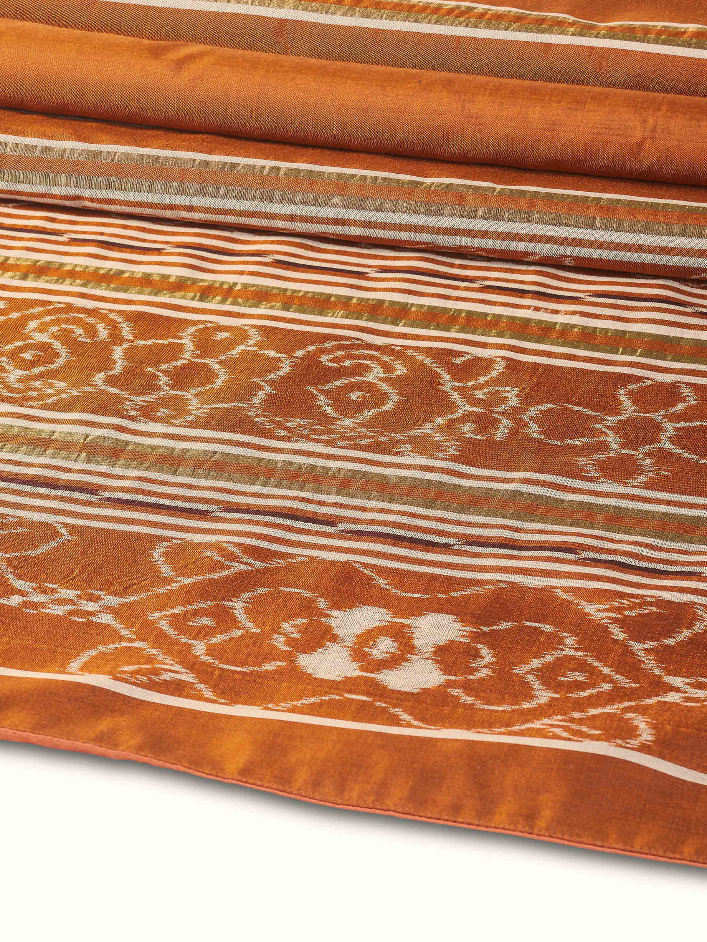 Folded silk bed runner showing thickness and artisanal detail.