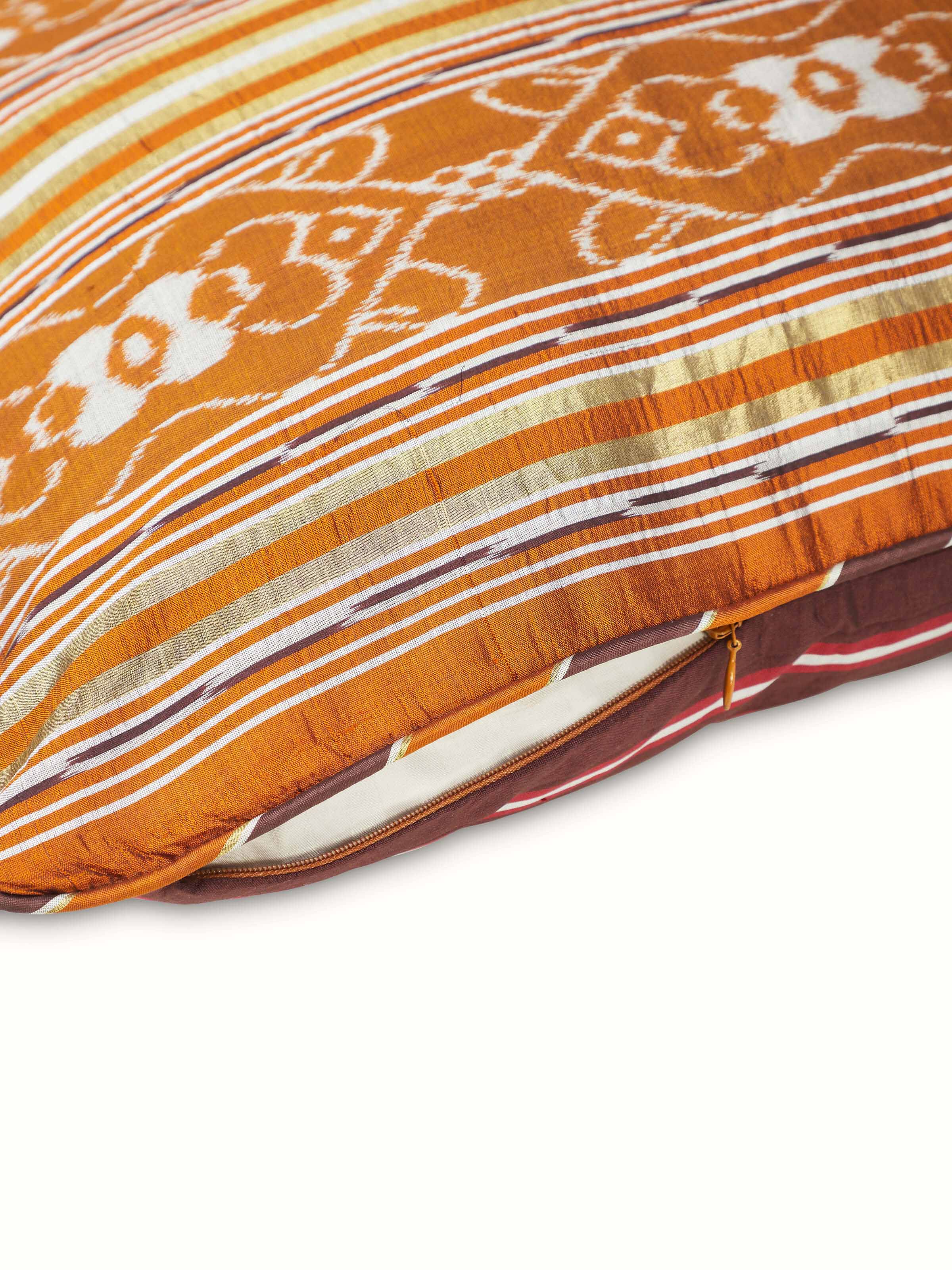 Side view of Sanchaya rust border stripe silk Odisha ikat handloom cushion cover, showing the cushion’s thickness and border details.