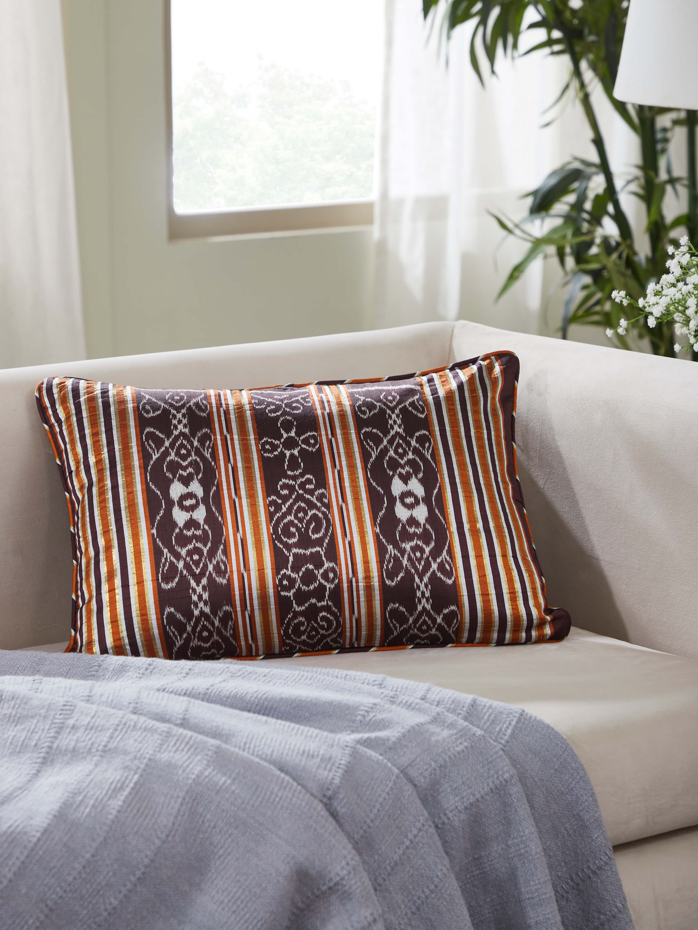 Full view of Sanchaya coffee stripe silk lumbar cushion cover with Odisha handloom Ikat pattern, highlighting its elegant stripes.