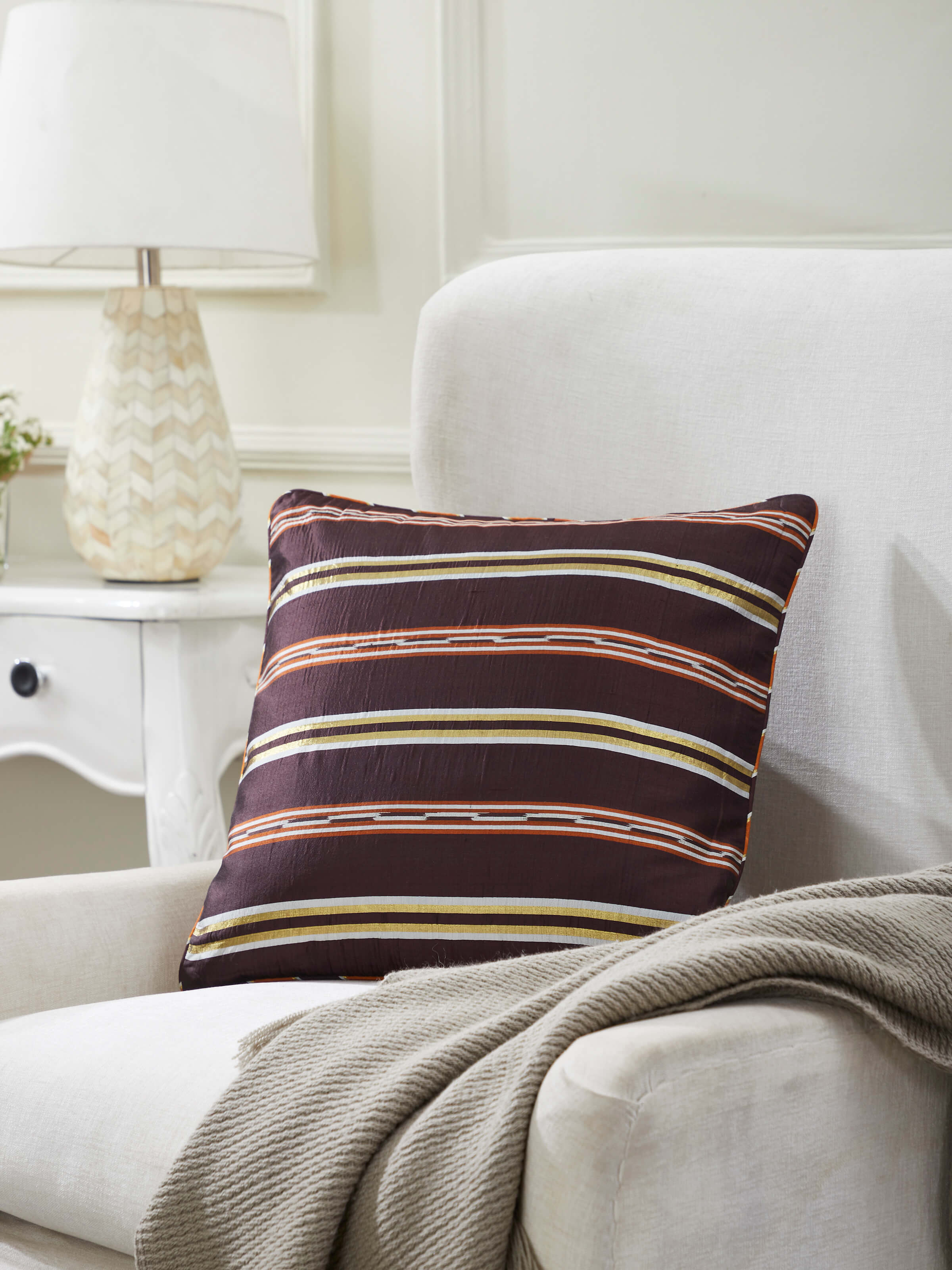 Side view of Sanchaya Coffee Stripe Silk Odisha Handloom Ikat Cushion Cover highlighting the edge and texture.