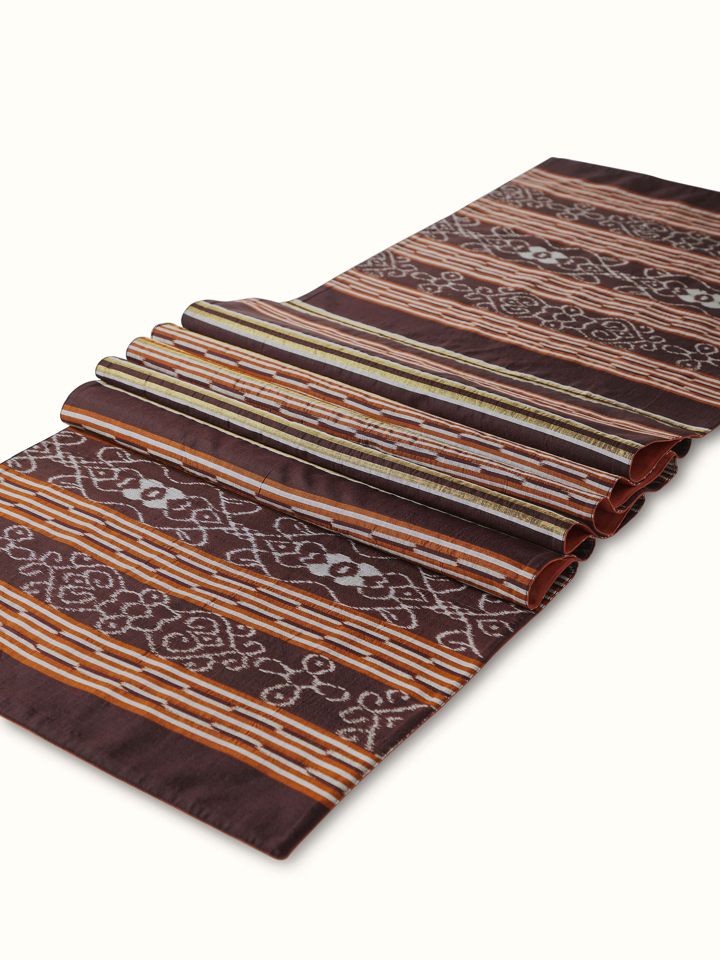 A detailed side view of the Sanchaya Coffee Stripe Silk Ikat Bed Runner, focusing on the delicate weave and traditional Indian Ikat dyeing technique used in Odisha.