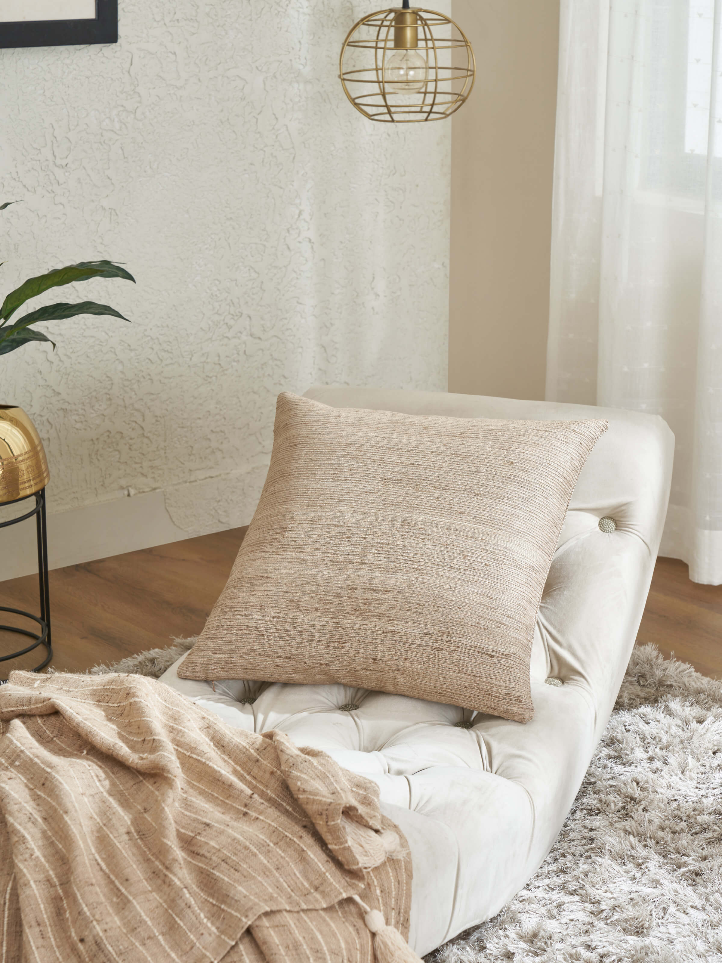 Lifestyle shot of grey silk cushion in a modern setup with muted decor tones.