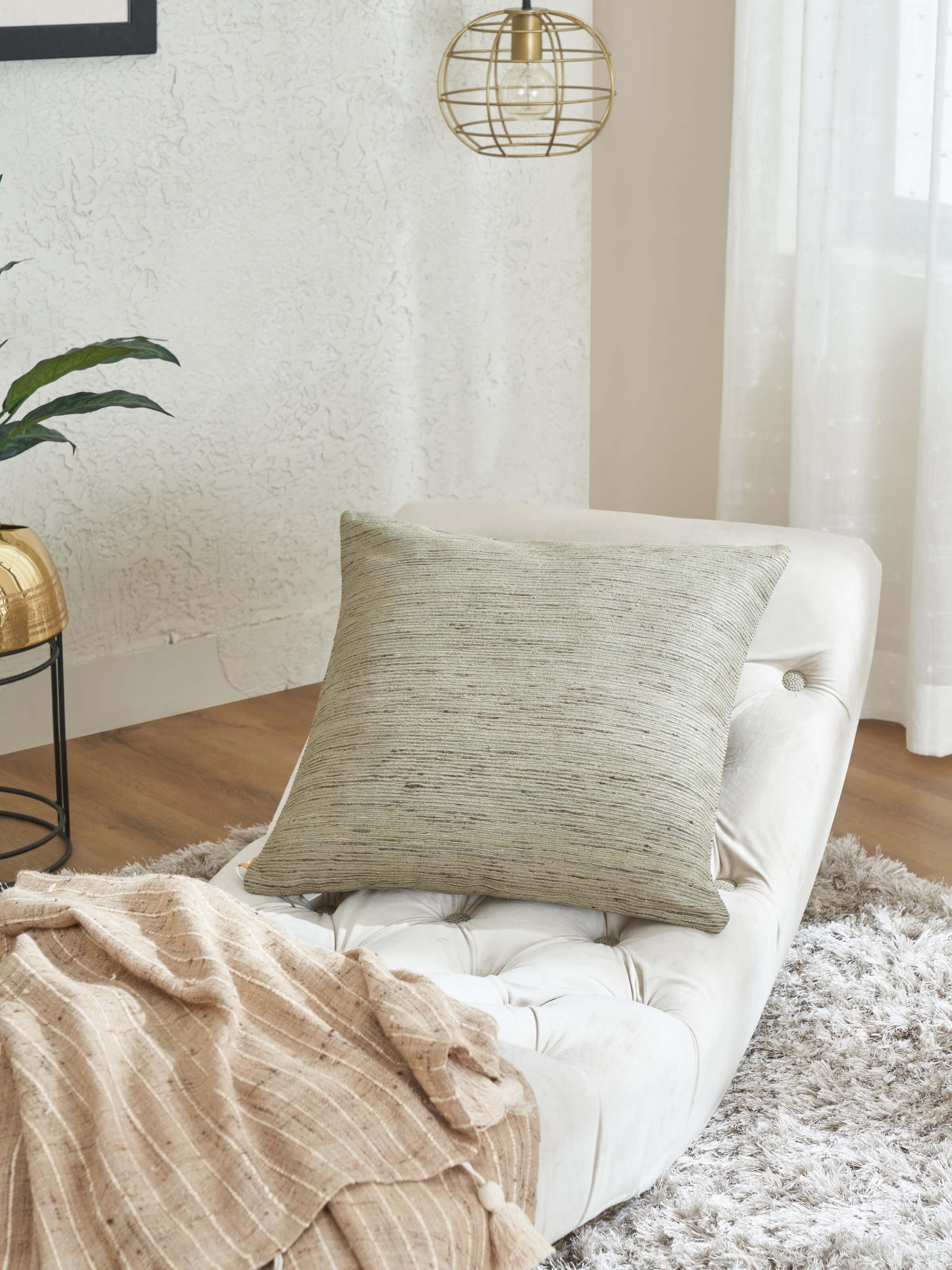 Ujjwal green cushion cover styled on a sofa in a modern living room setup