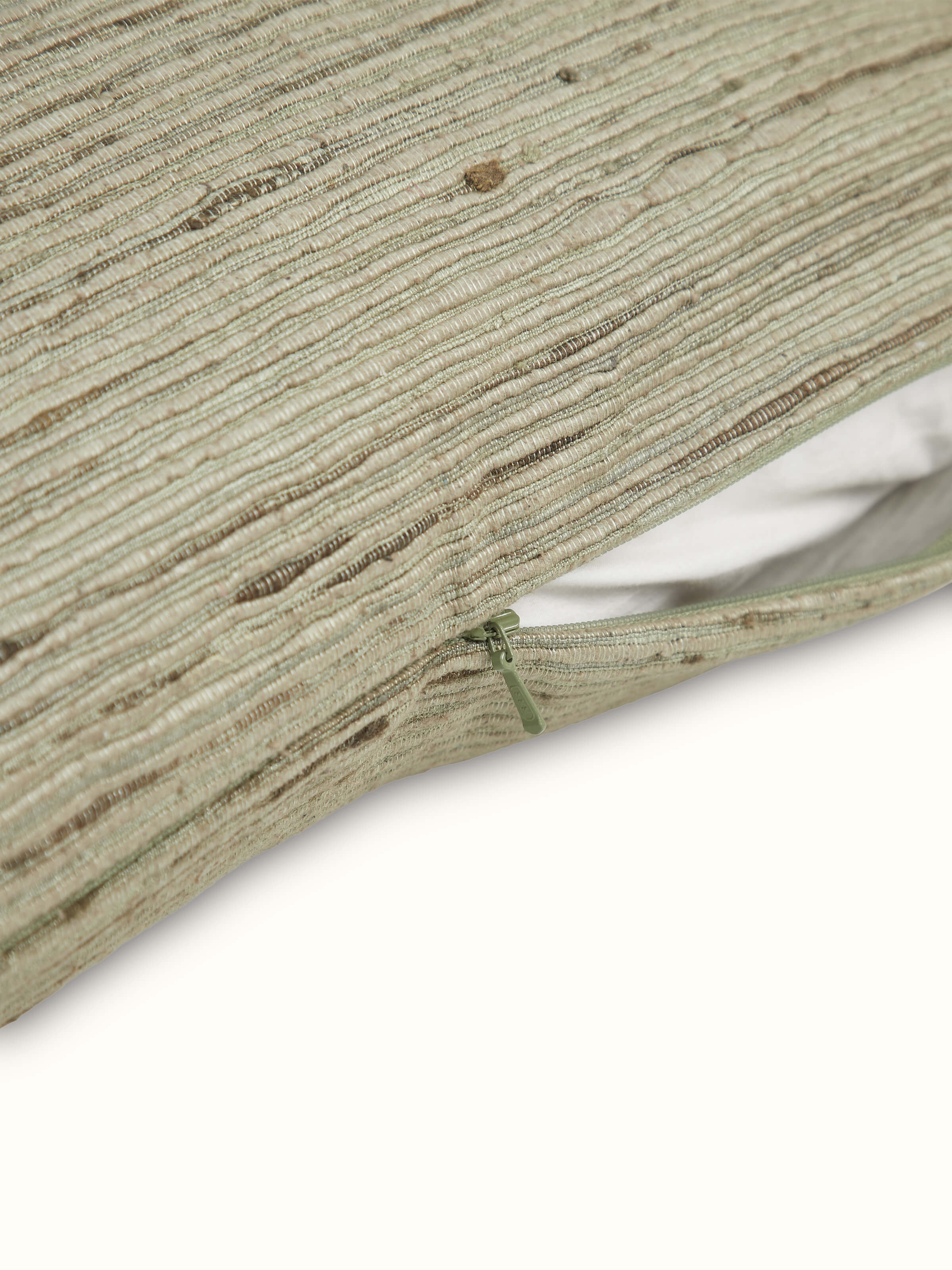 Side view of Ujjal Light Green Niyama Silk Slub Handloom Cushion Cover highlighting the cushion's shape and silk slub texture.