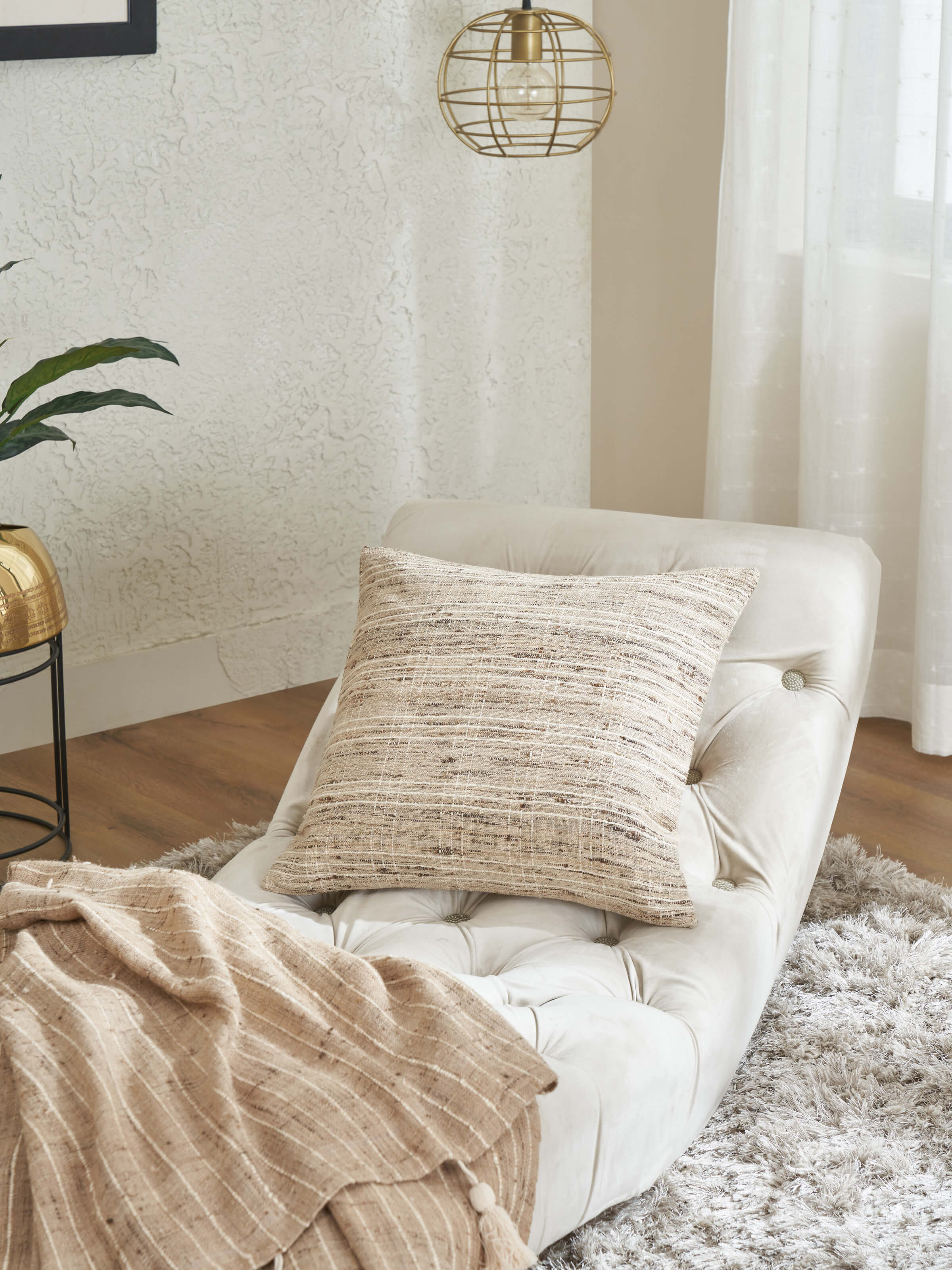 Lifestyle shot showing brown checkered silk cushion cover styled on a neutral sofa.