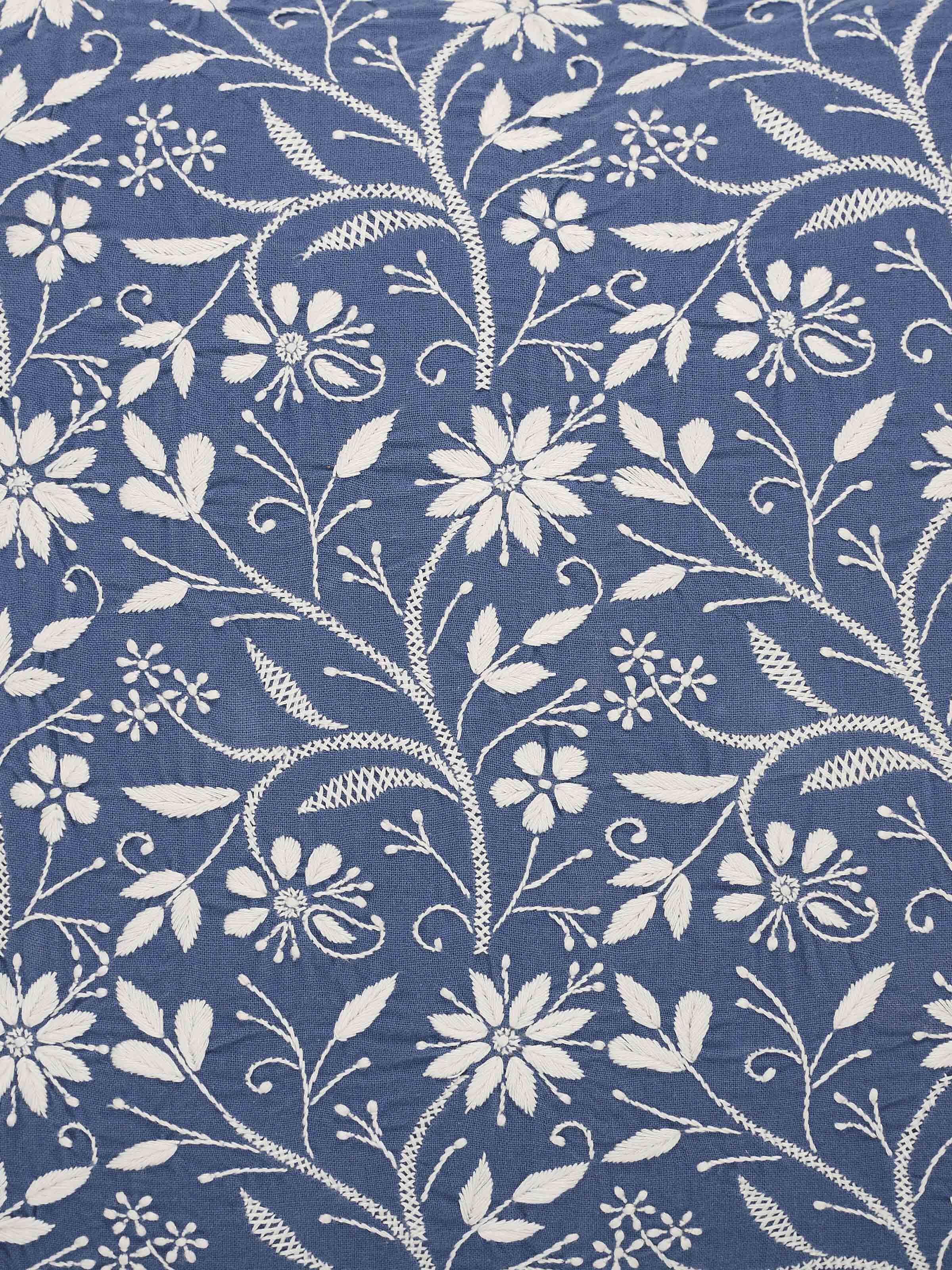 Detail shot of intricate threadwork and soft cotton texture.