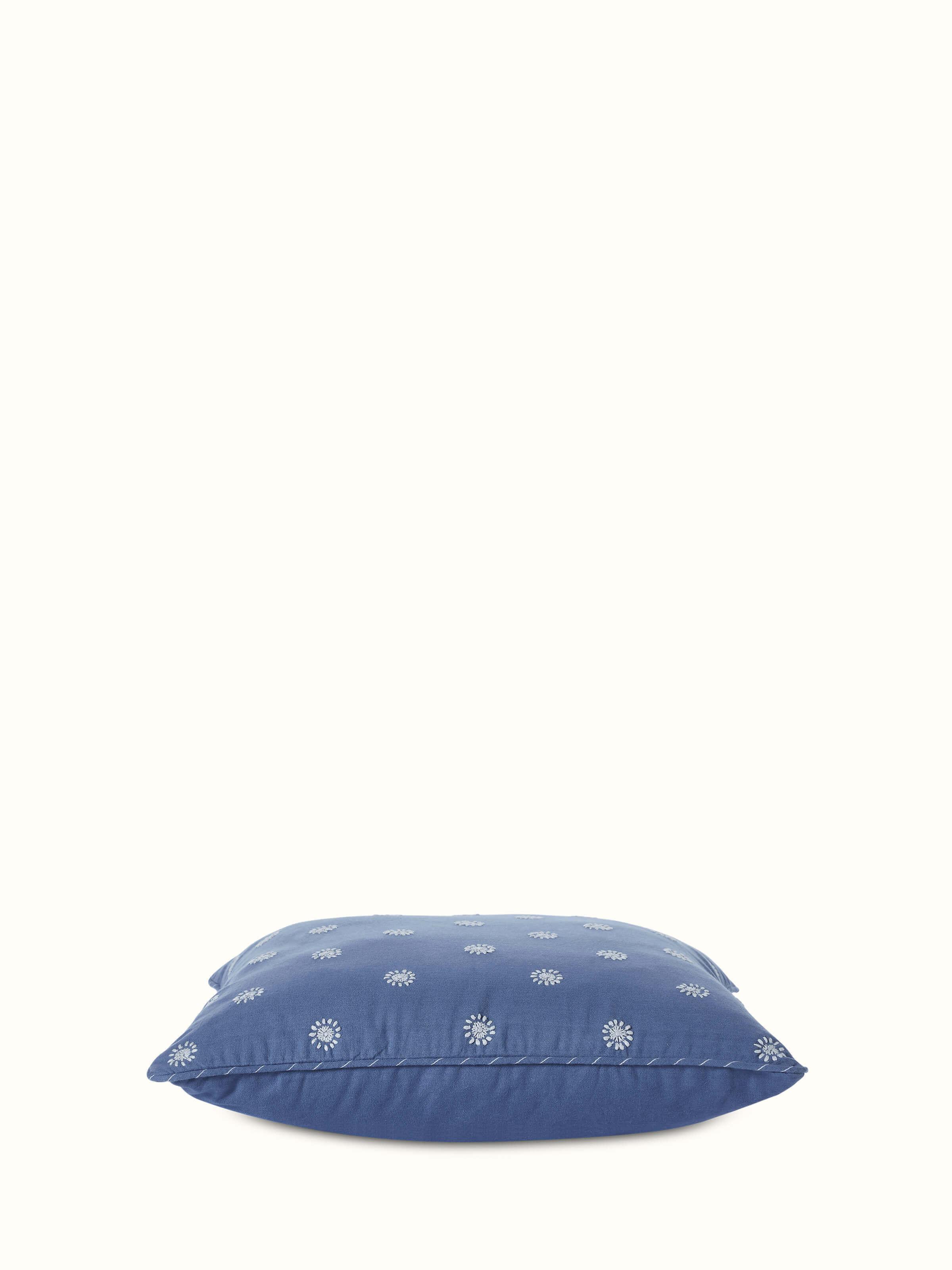 Angled view of Chikankari cushion cover highlighting intricate hand embroidery and fine cotton texture.
