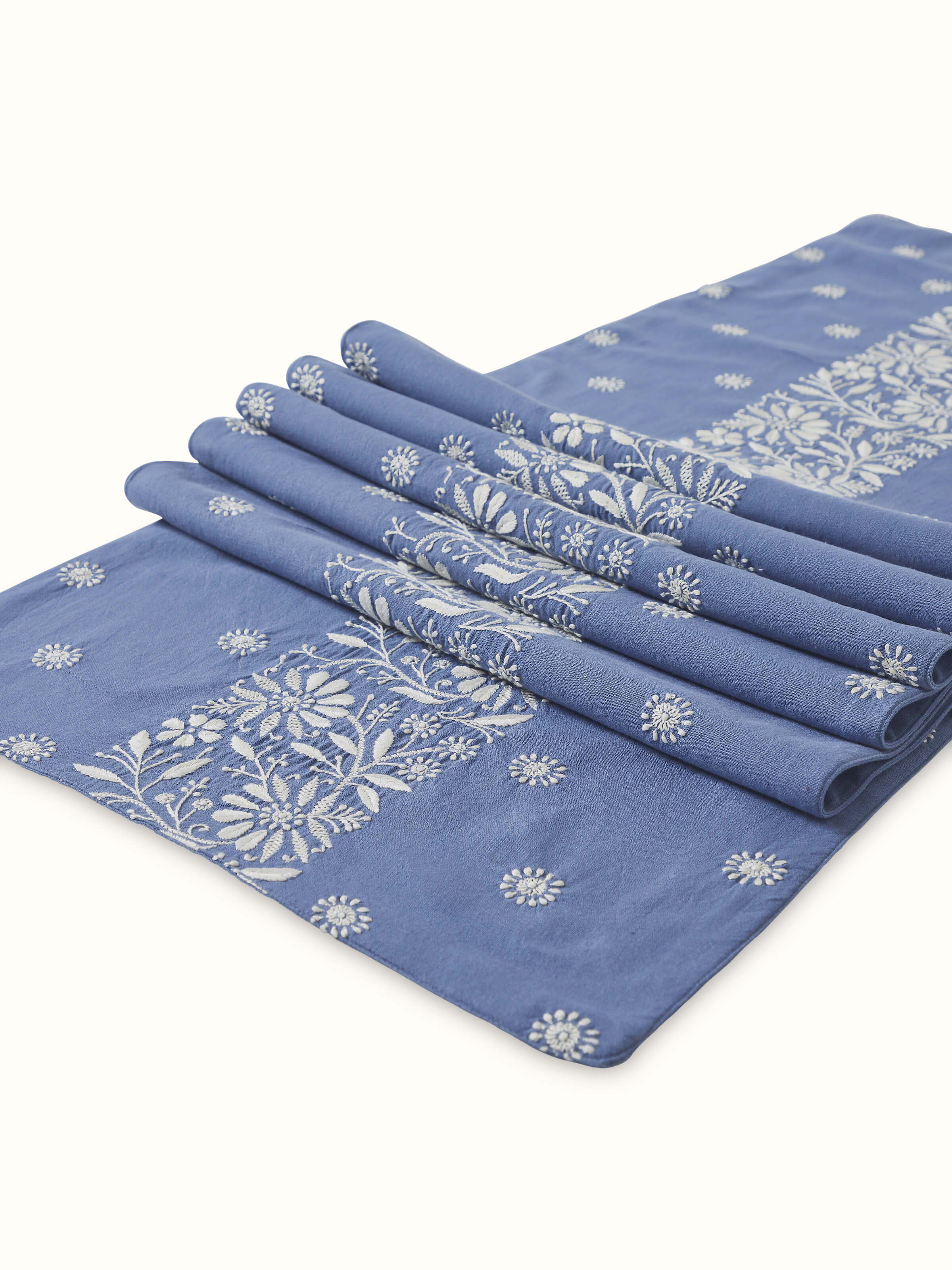 Detail shot of intricate Chikankari embroidery on Rann blue border linen bed runner.