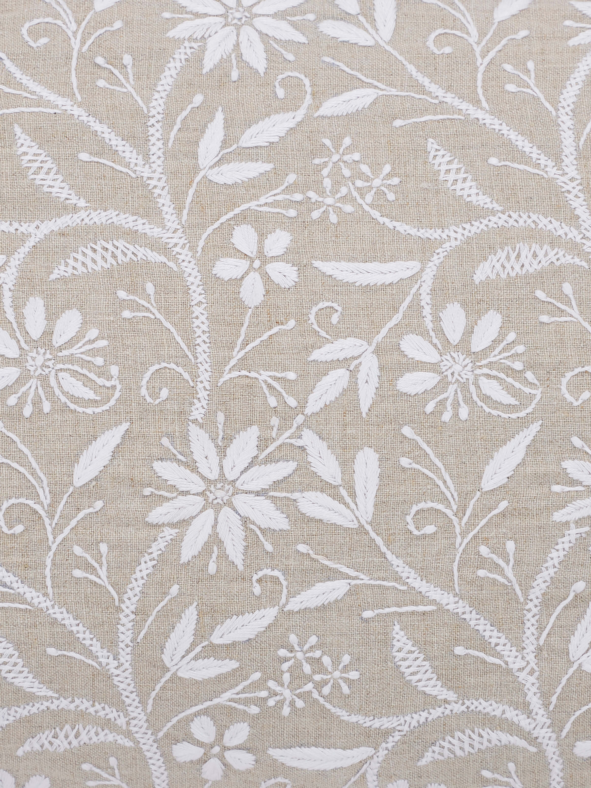 Perspective view of Rann beige allover cotton Chikankari hand embroidered cushion cover showing its elegant embroidery and beige cotton fabric.