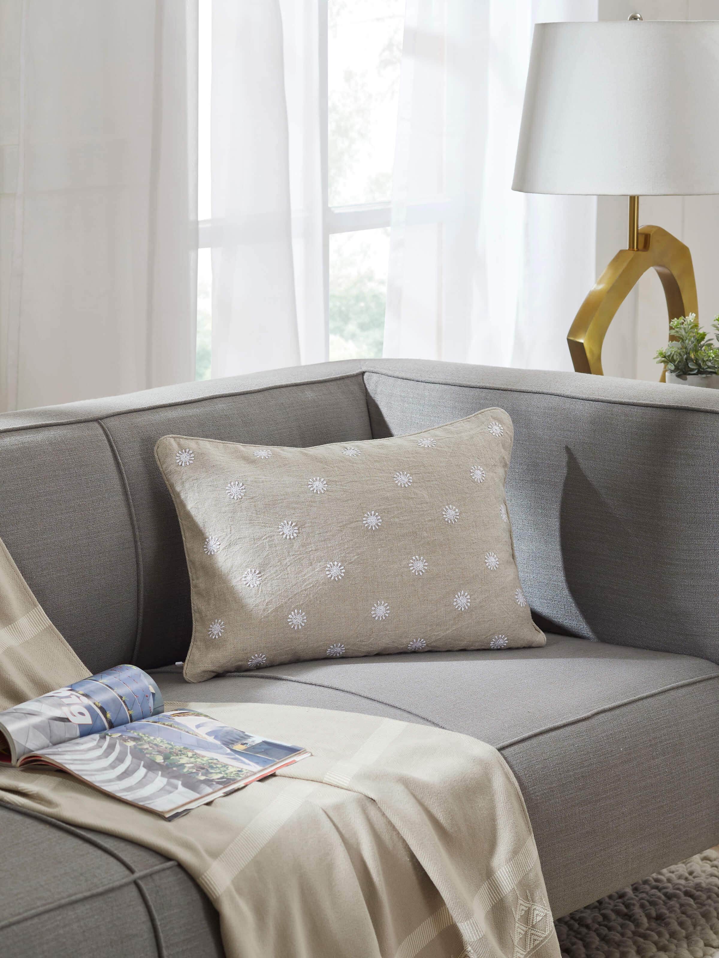Close-up of Rann beige buti linen Chikankari hand embroidered lumbar cushion cover highlighting the fine embroidery details.
