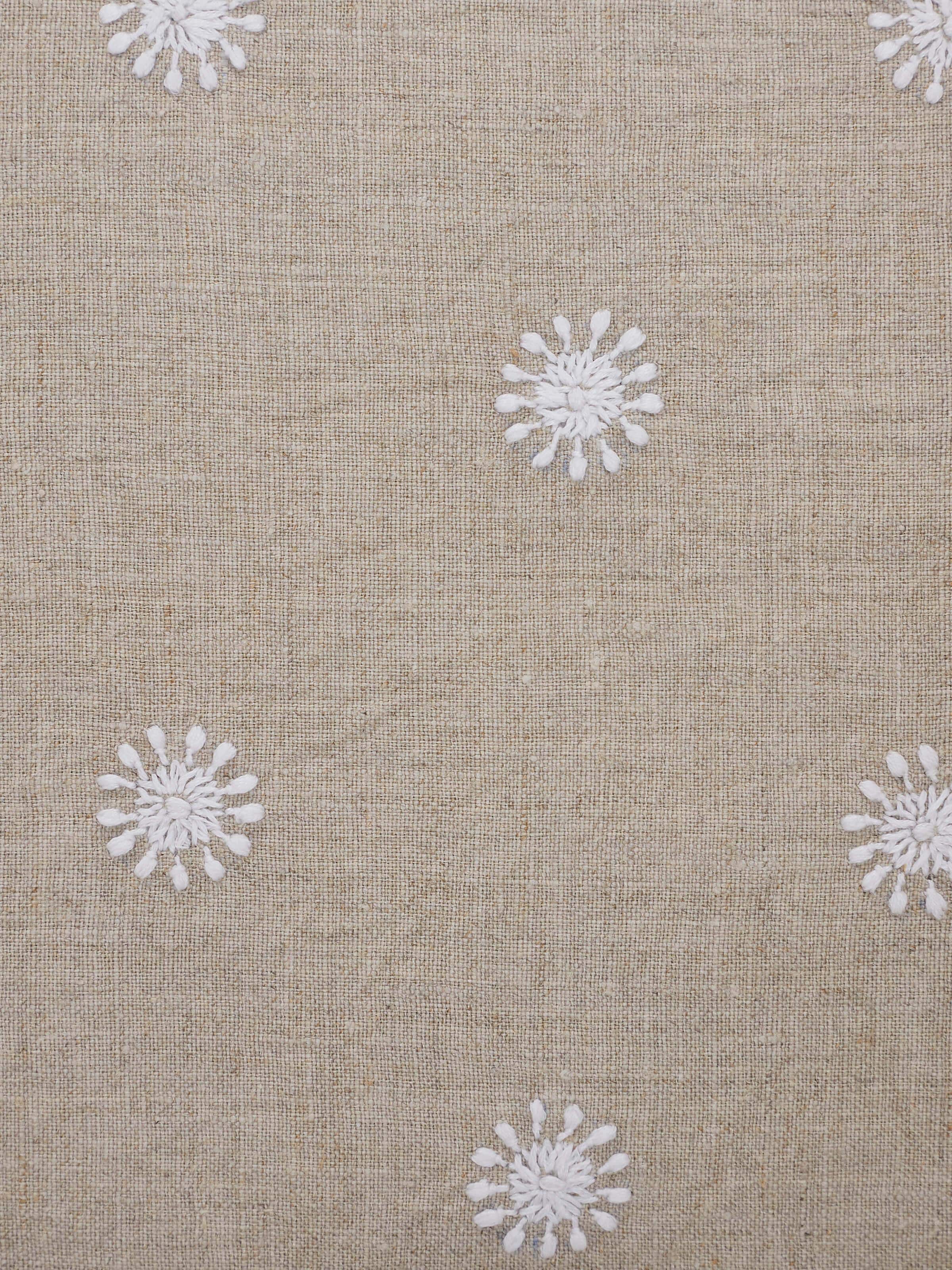 Rann beige buti linen Chikankari hand embroidered lumbar cushion cover displayed in a setting to show its decorative use.