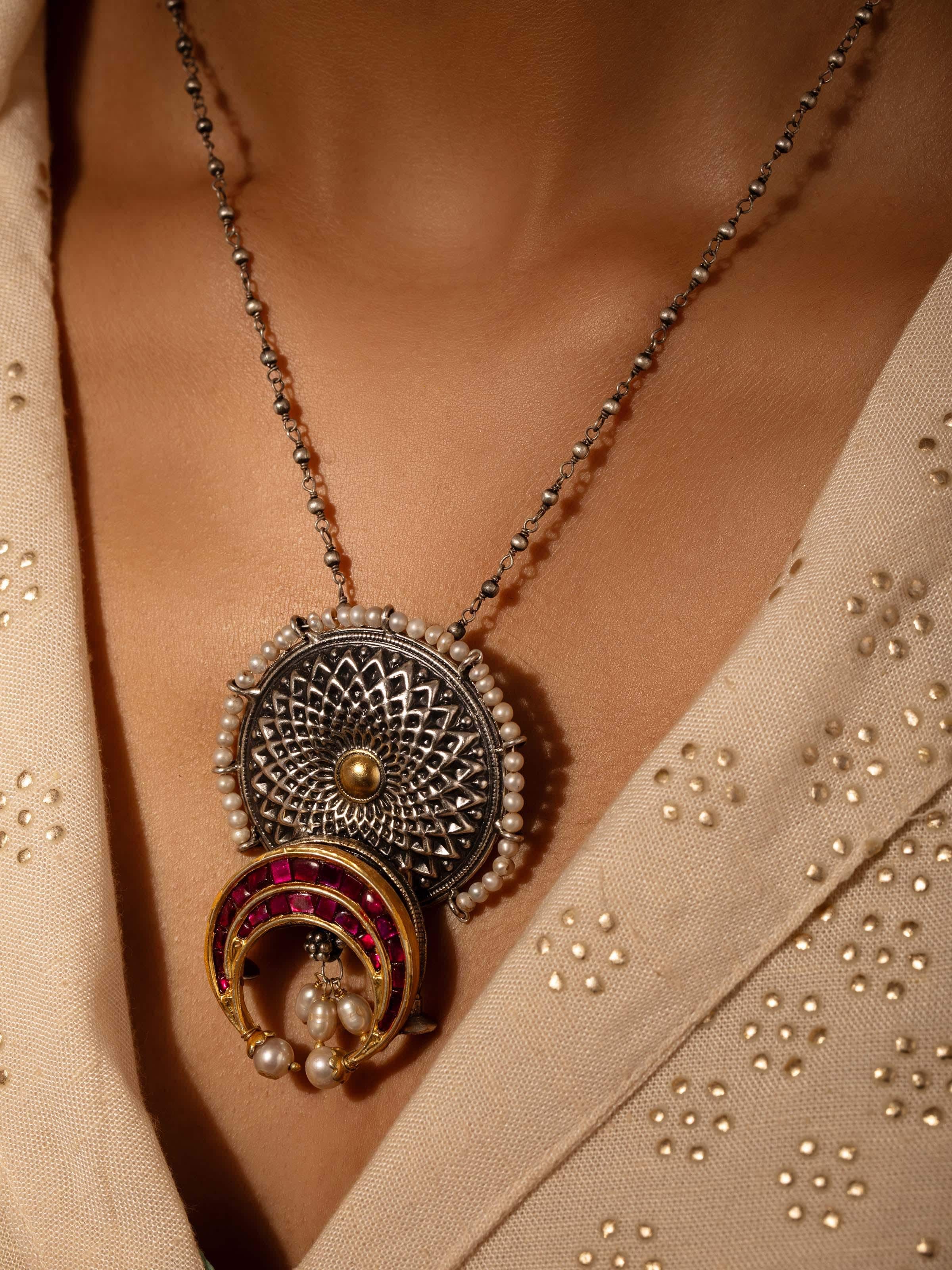 Close-up view of silver smithing pendant & chain emphasizing the fine details