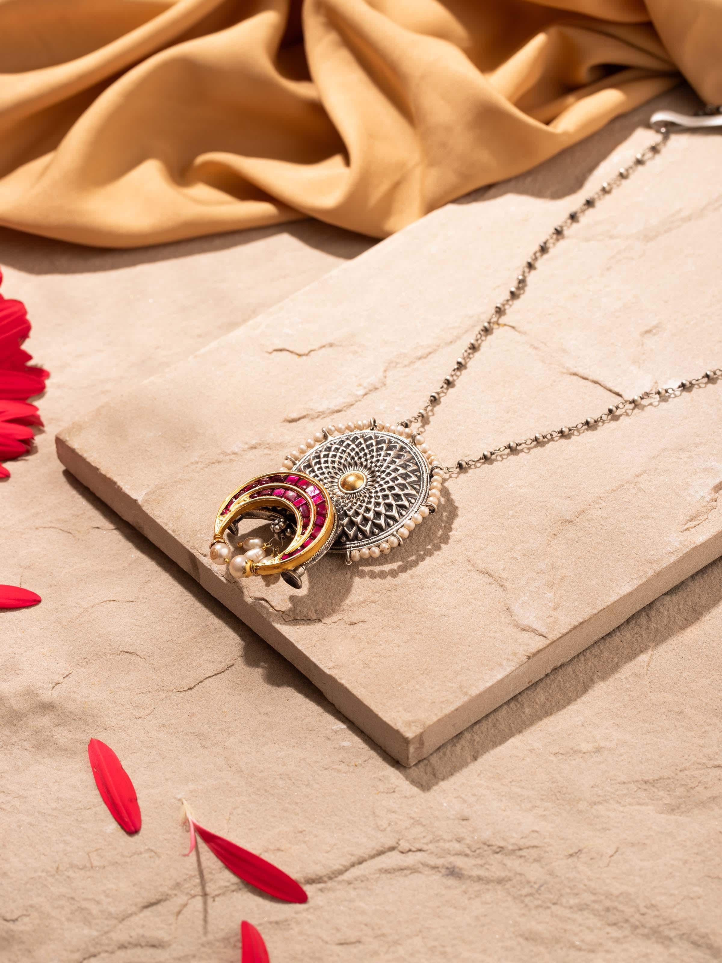 Angled view of silver smithing pendant & chain with a sophisticated design