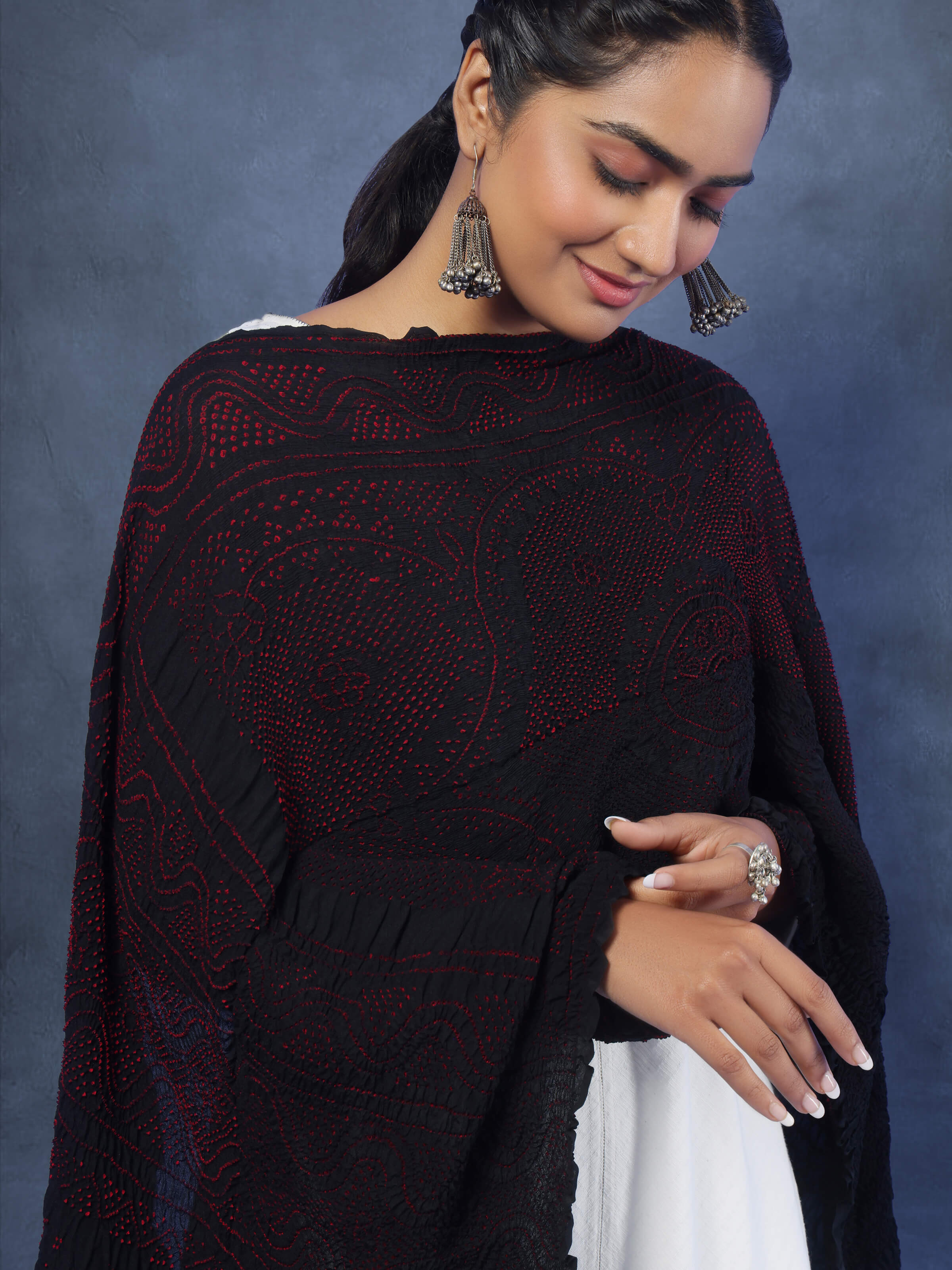 Detailed angled view of red Bandhani silk dupatta showcasing rich texture and traditional pattern.