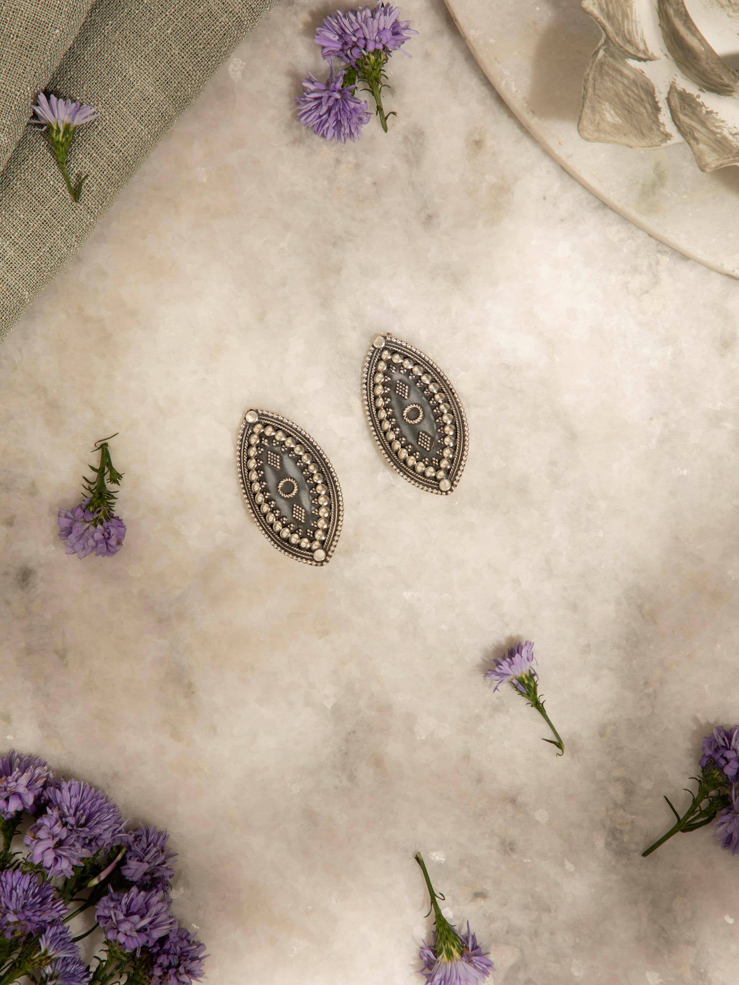 Angled view of Silver Smithing Stud Earrings showcasing overall design and craftsmanship.