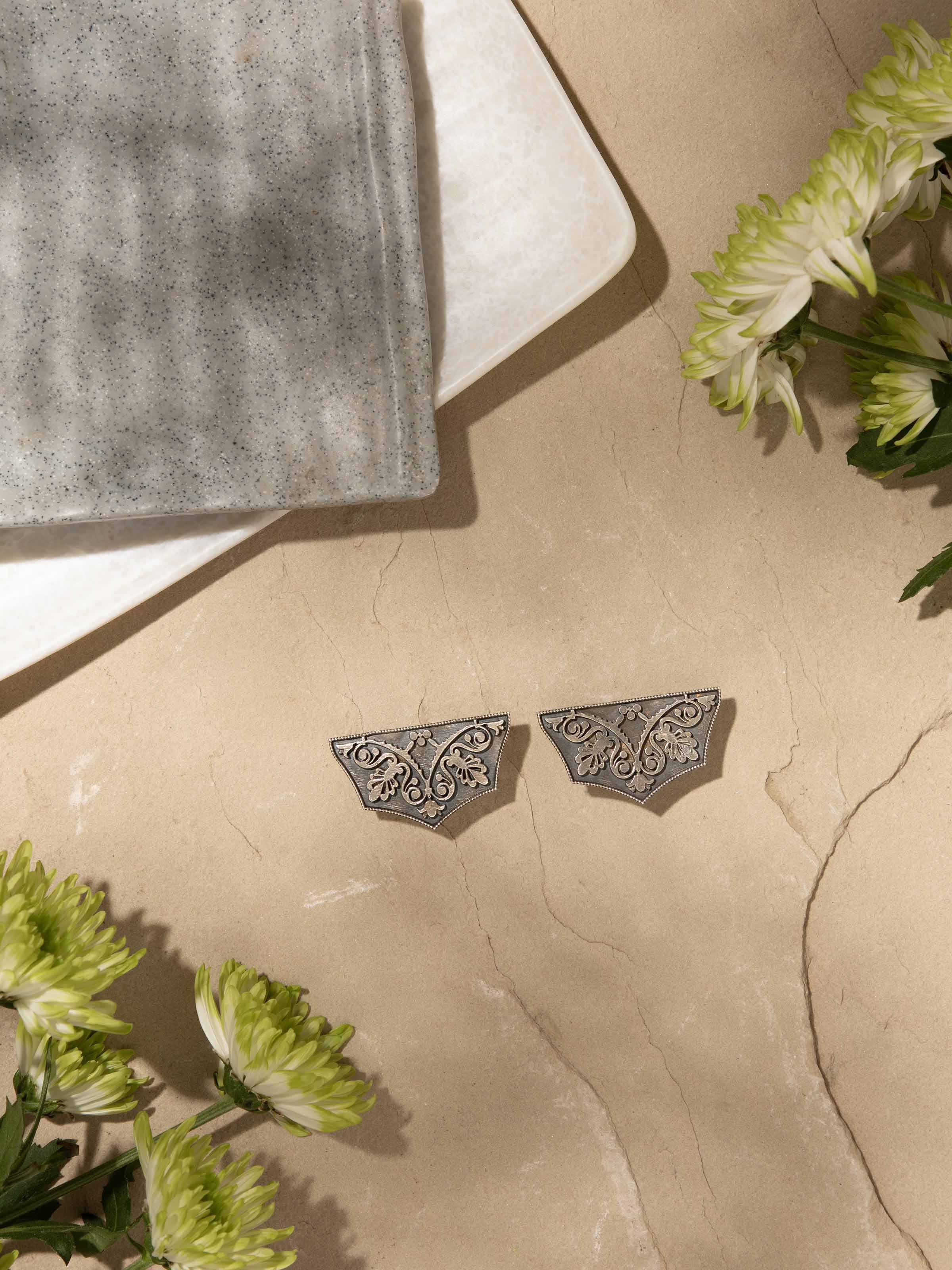 Angled view of Silver Smithing Stud Earrings showcasing refined silver detailing.