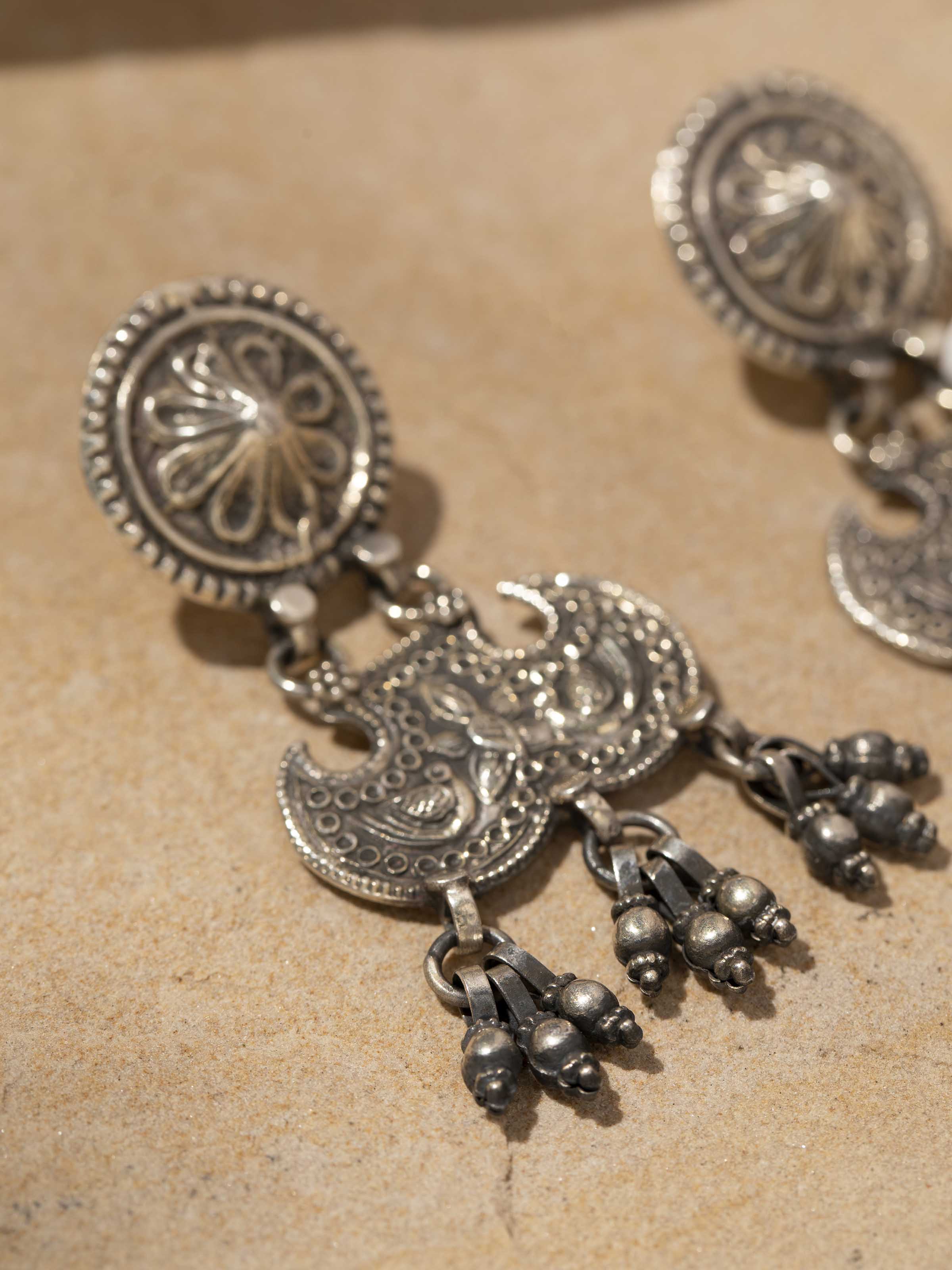 Detailed close-up of Smithing Drop Earrings with emphasis on elegant design and smooth metal finish.
