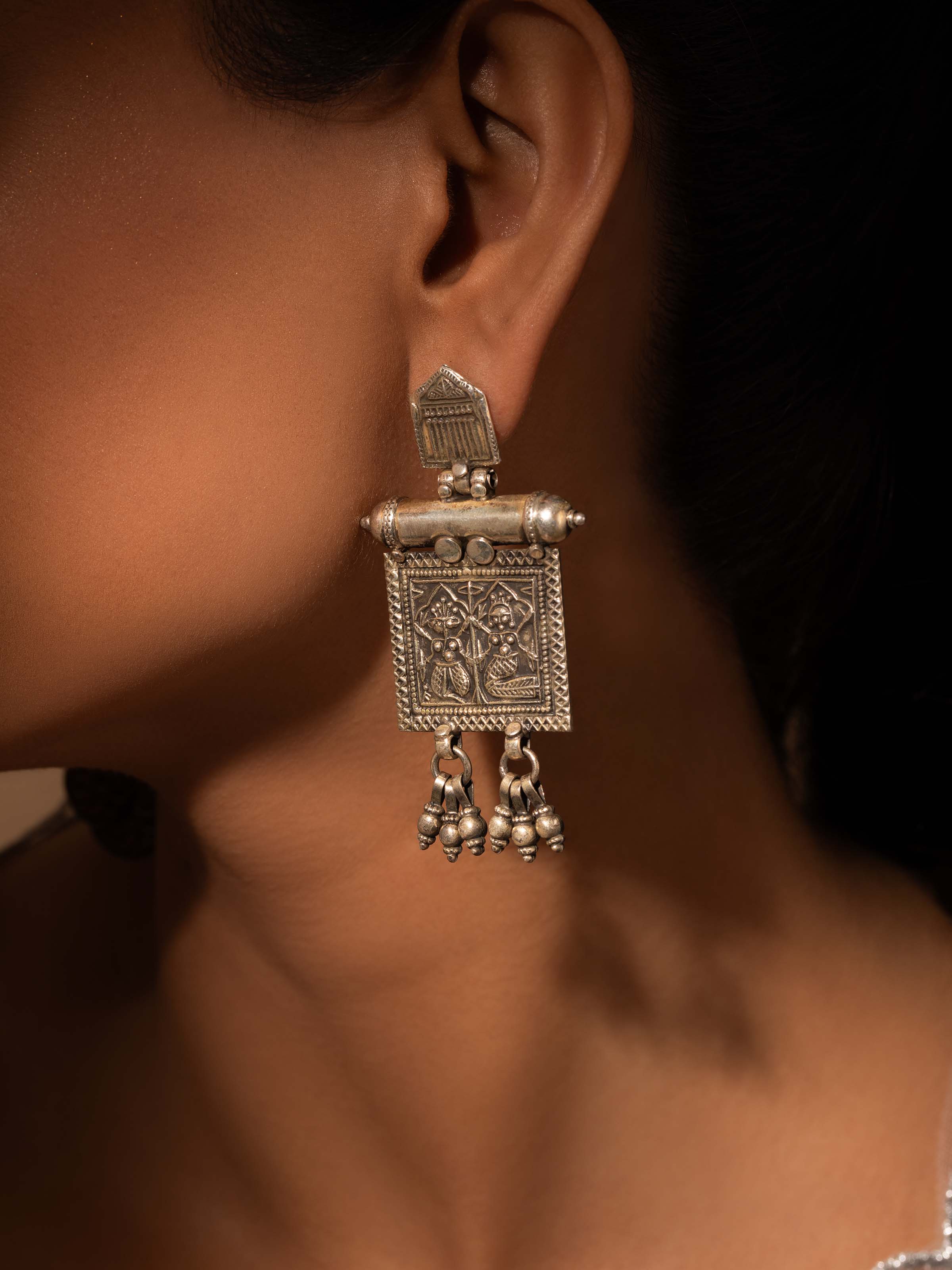 Side view of Smithing Drop Earrings showcasing the refined metal detailing and elegant drop shape.